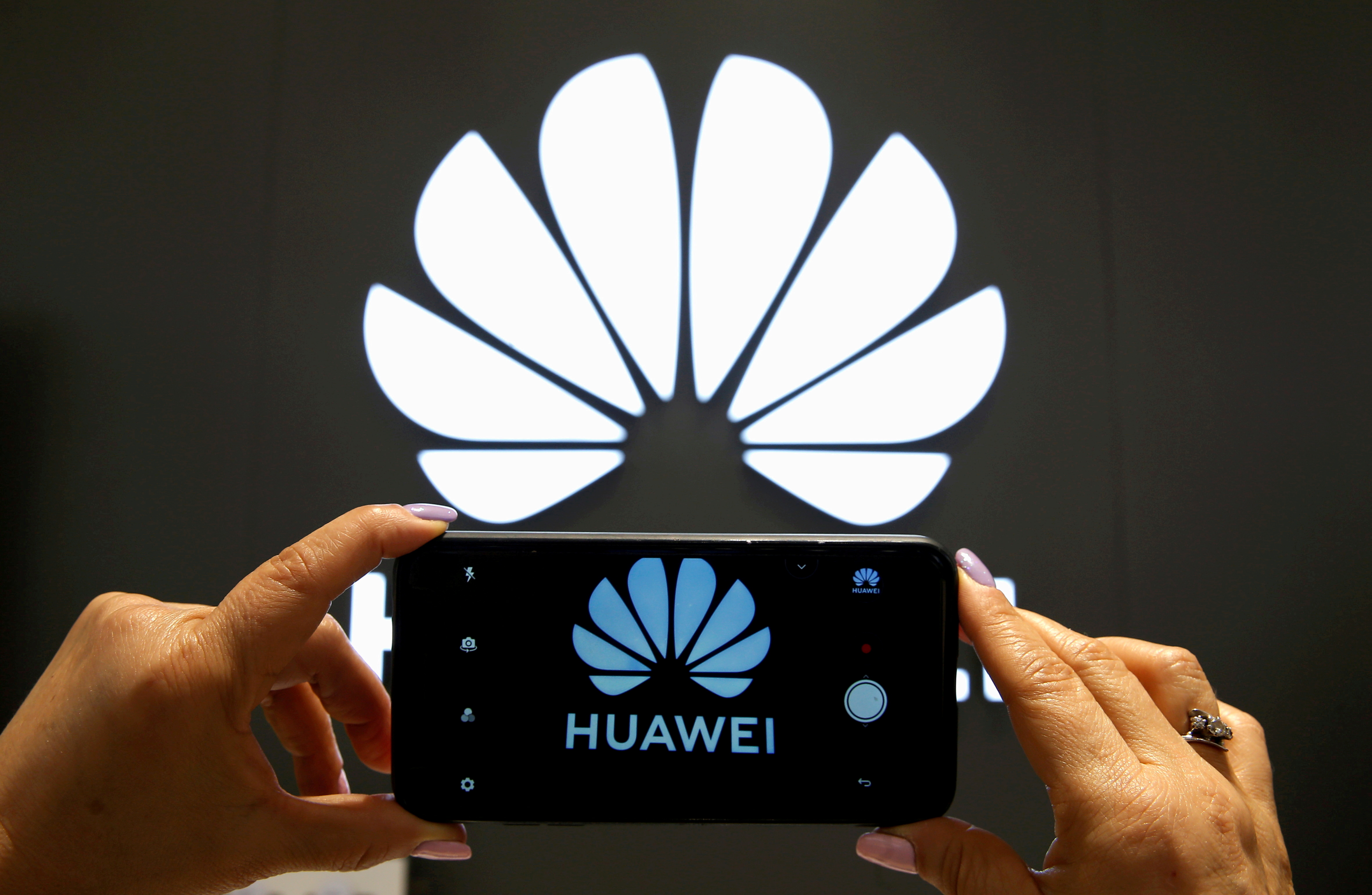 A Huawei logo is seen on a cell phone screen in their store at Vina del Mar
