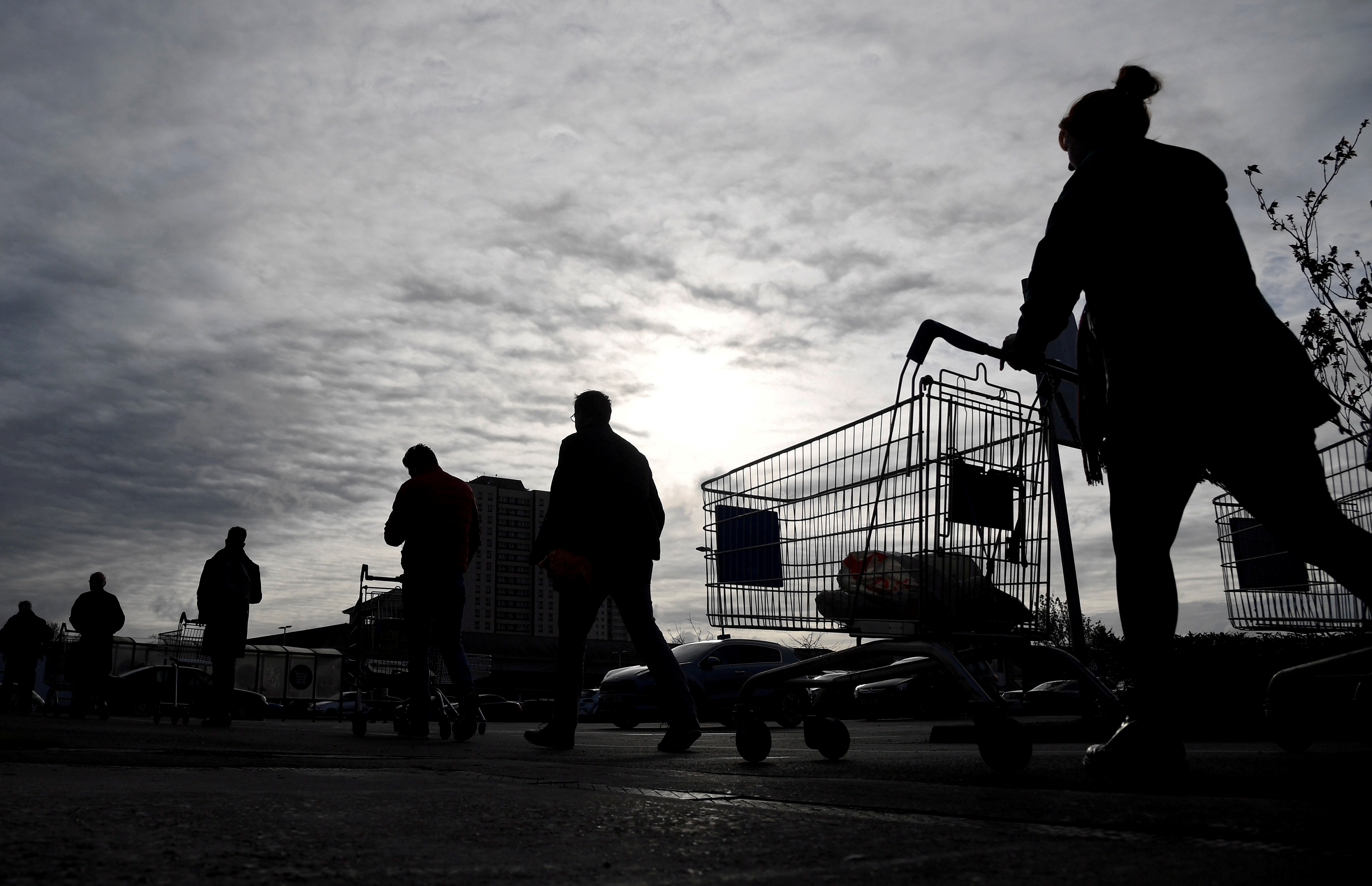 FILE PHOTO: Shoppers queue to enter a Tesco supermarket in West London