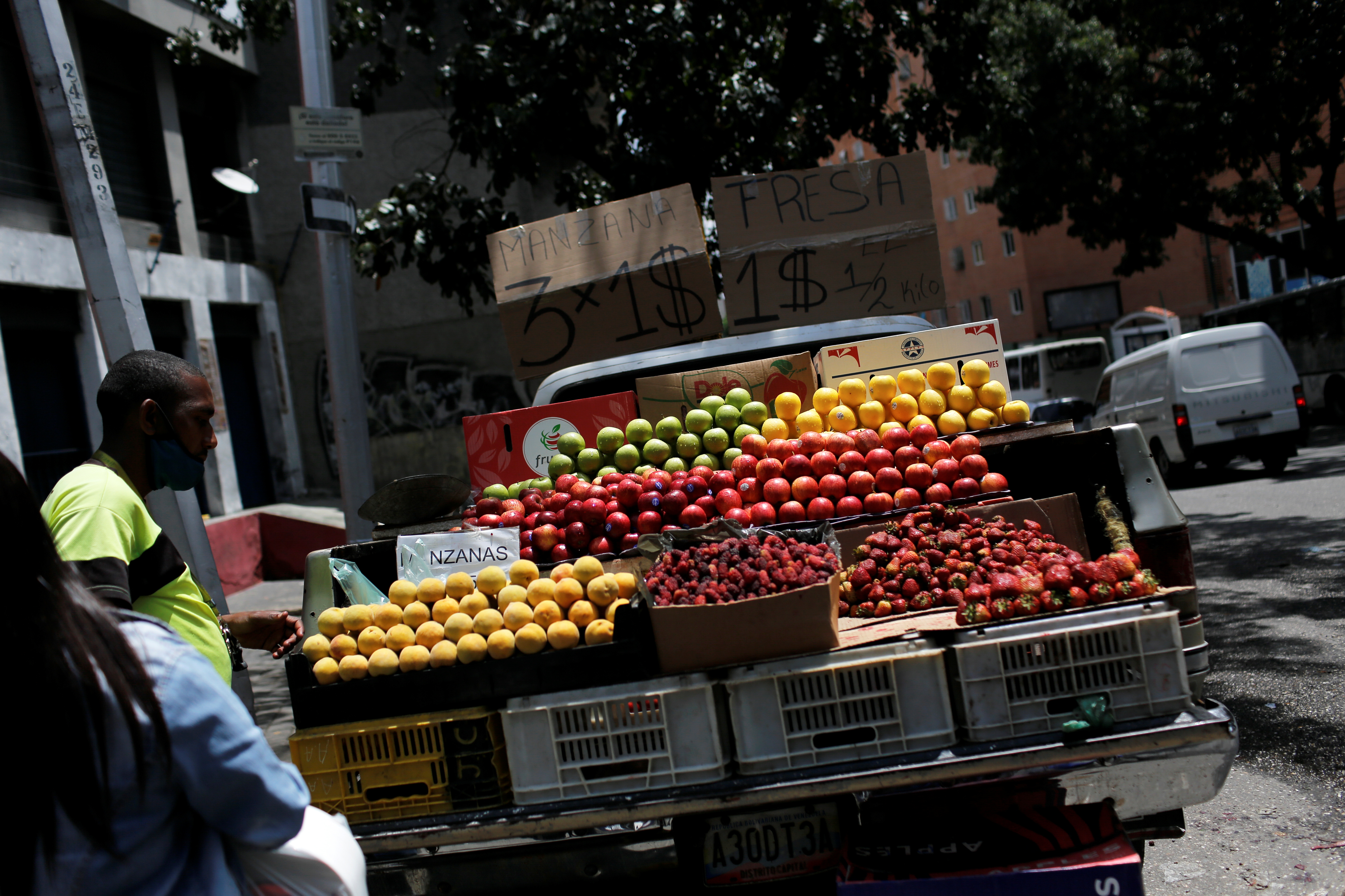 A street vendor sell fruits priced in US dollars in Caracas