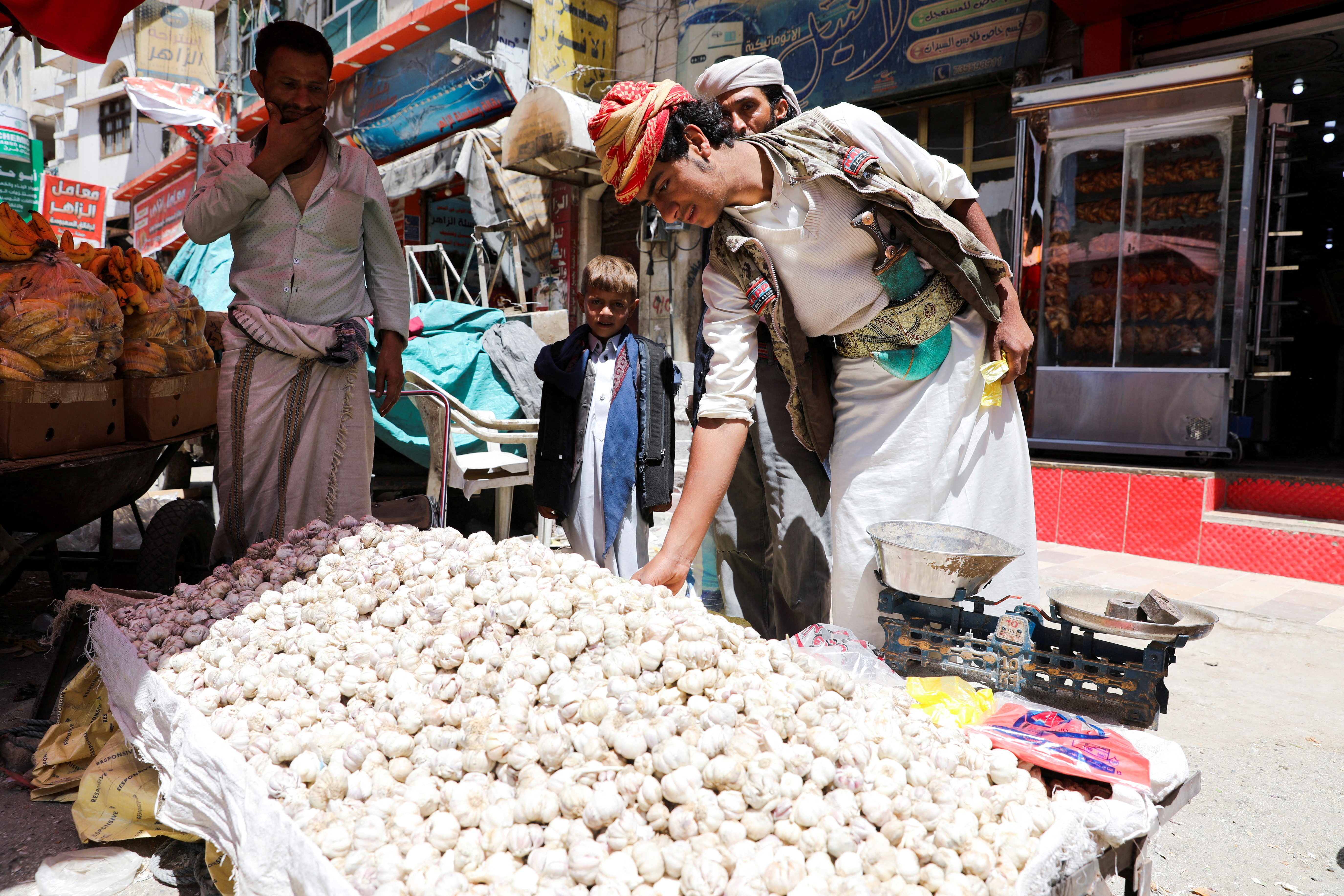 Vendors selling bread wait for customers on a street as Yemenis prepare for the fasting month of Ramadan amid war in Ukraine and soaring food prices, in Sanaa