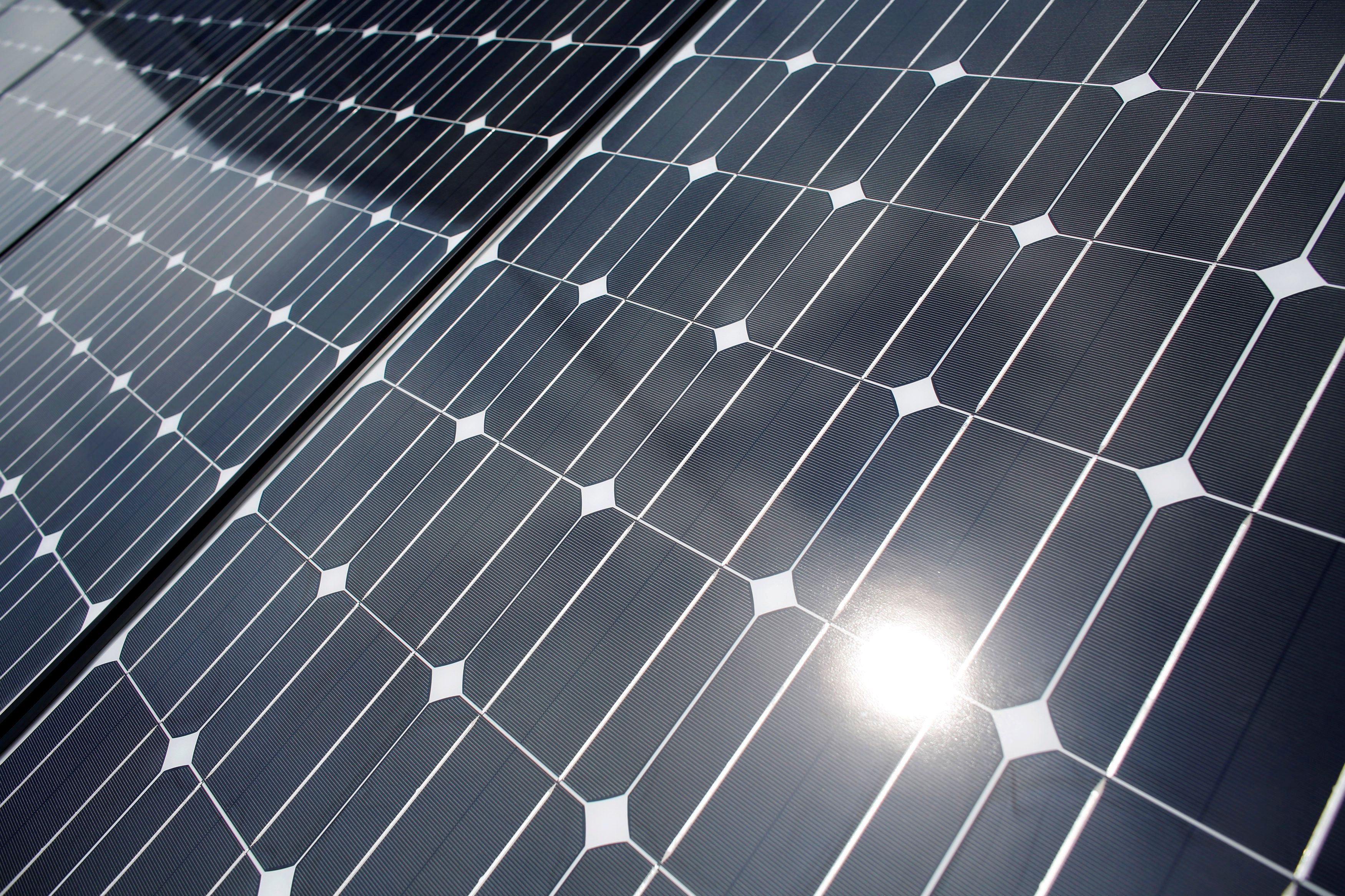 The sun is reflected on a solar panel at a solar power field in Kawasaki, near Tokyo