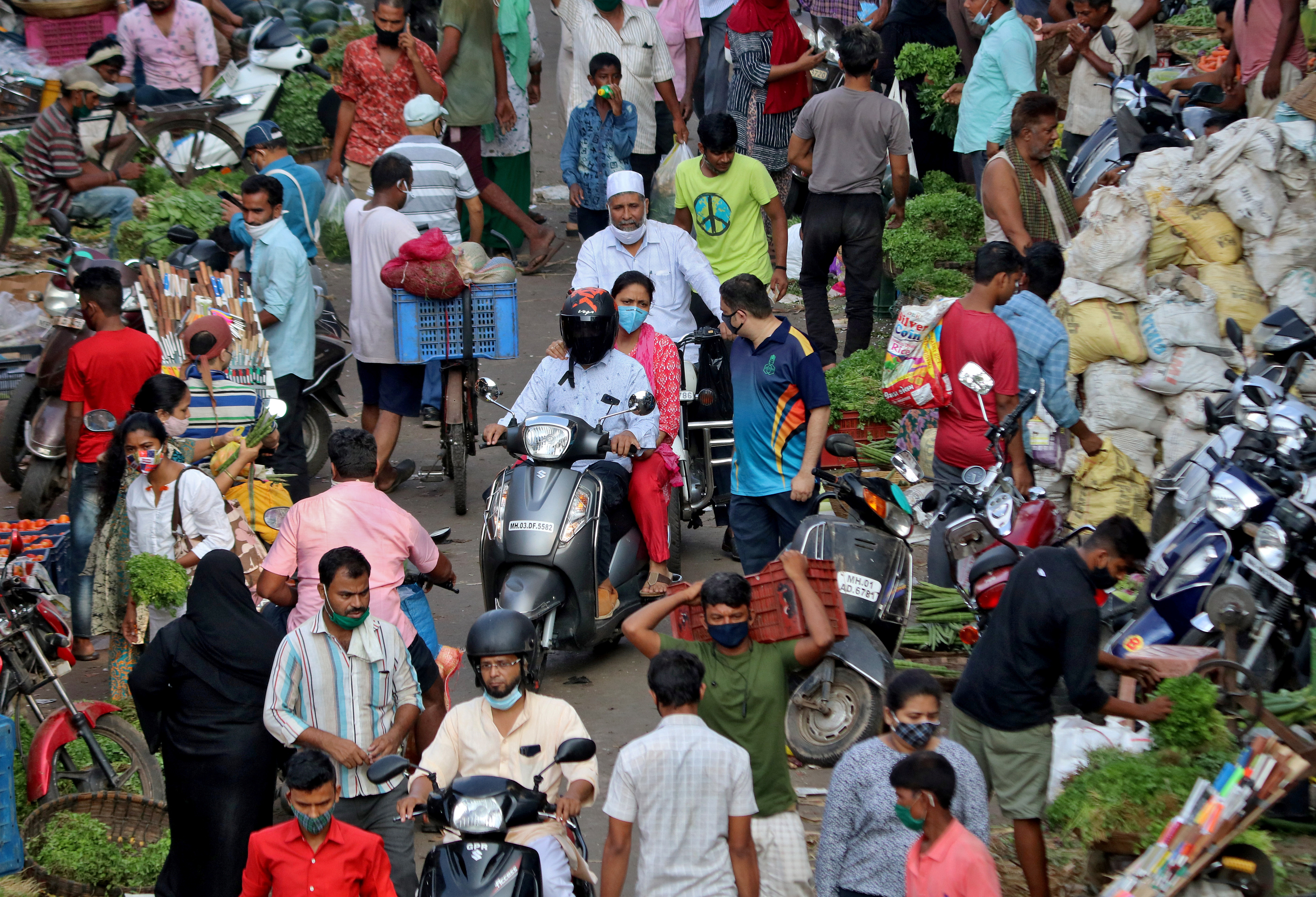 People shop at a crowded vegetable market amidst the spread of the coronavirus disease (COVID-19) in Mumbai