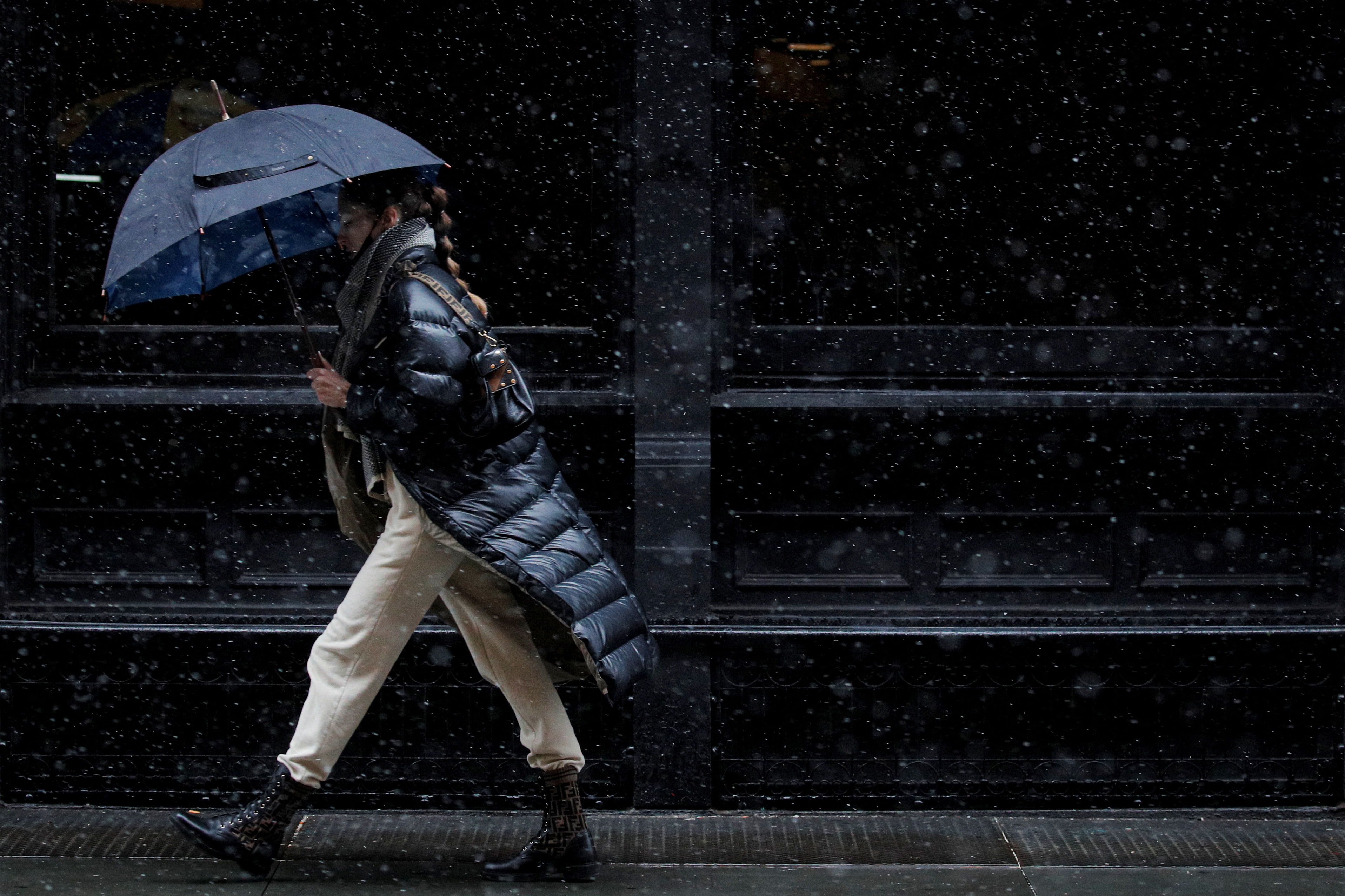 A woman walks in the snow in the Manhattan borough of New York