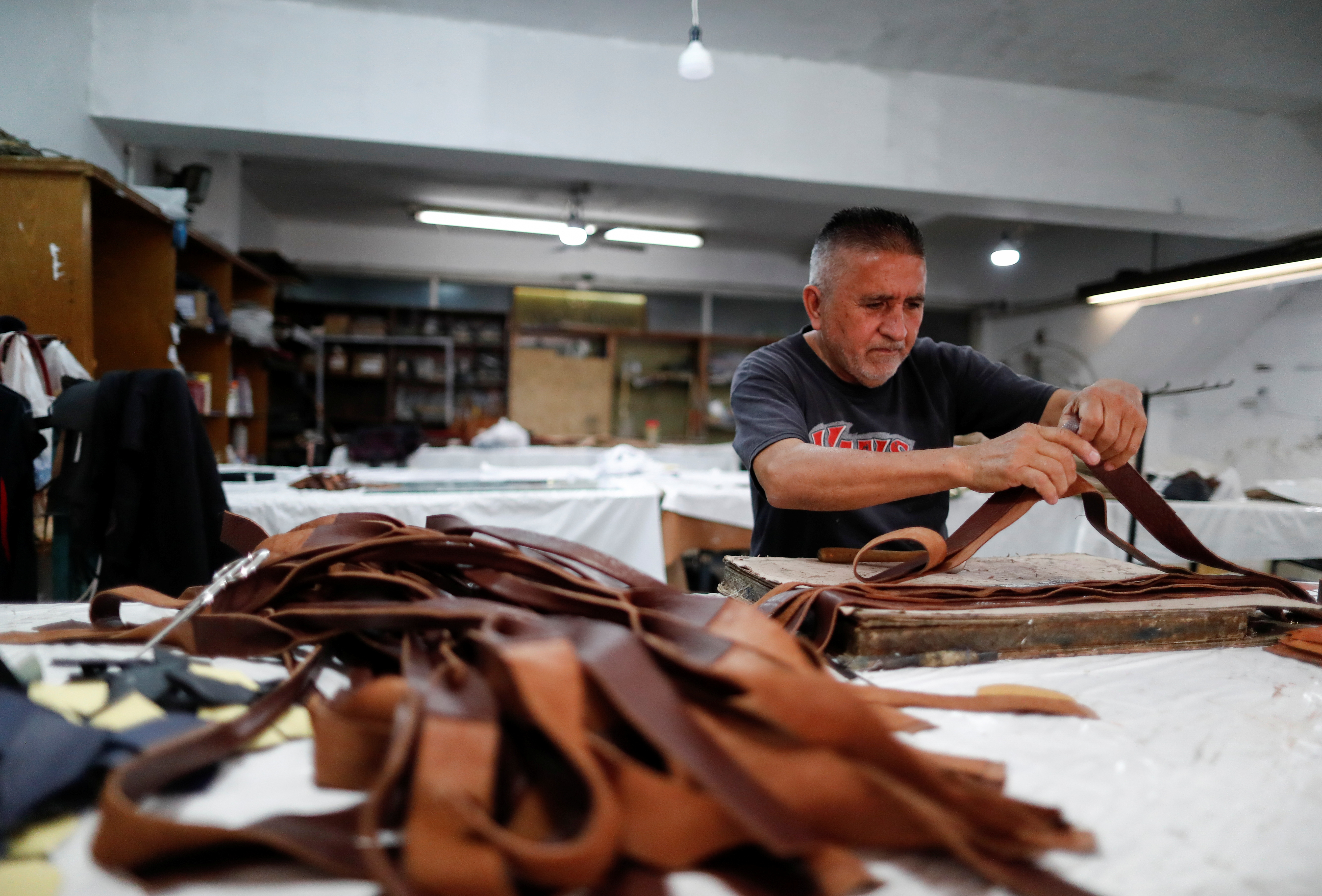 Hugo, a member of the Renacer cooperative works with plastic waste-leather for the fashion firm Fracking Design making sandals, in Buenos Aires, Argentina November 24, 2021. Picture taken November 24, 2021. REUTERS/Agustin Marcarian
