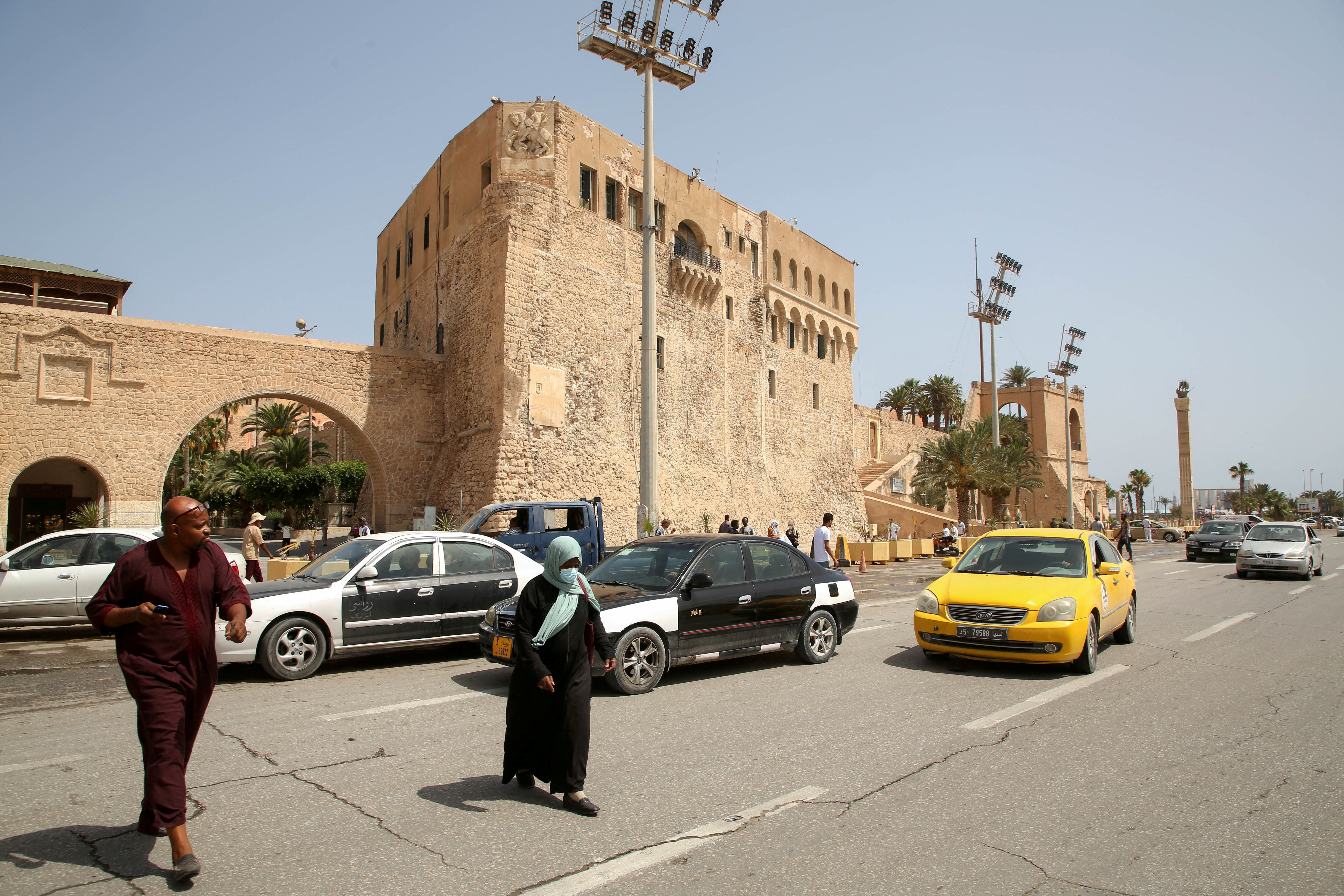 People cross a street at Martyrs Square in Tripoli