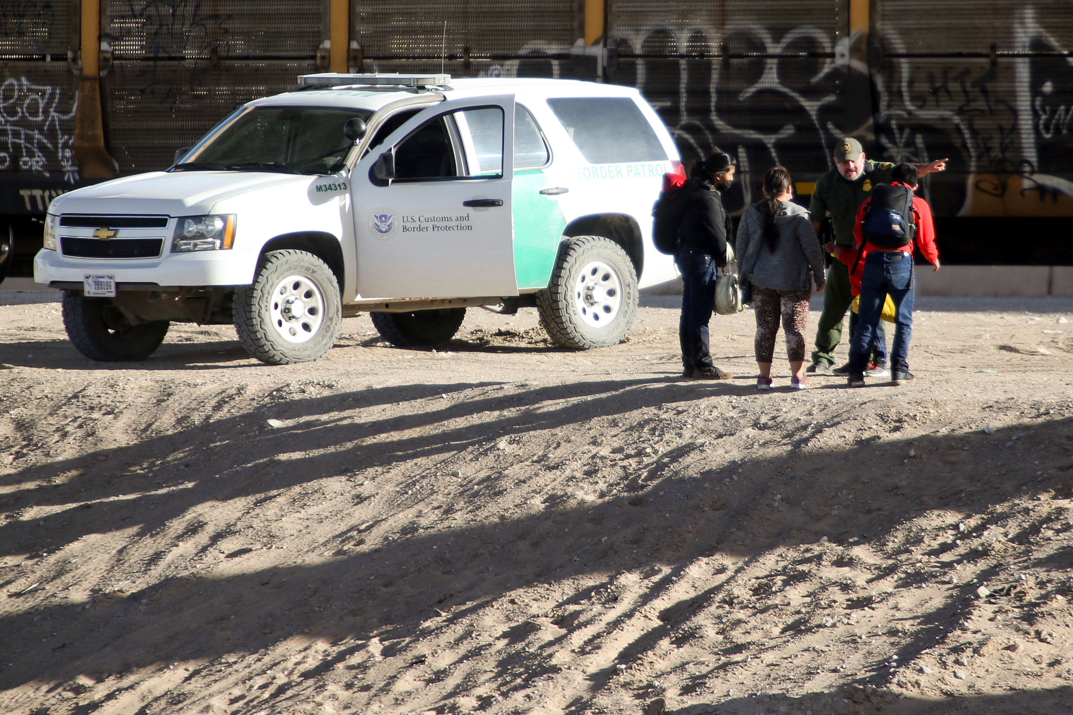Migrants are detained by a U.S. Border Patrol agent after crossing the Rio Bravo river to turn themselves to request for asylum in El Paso, Texas, U.S., as seen from Ciudad Juarez