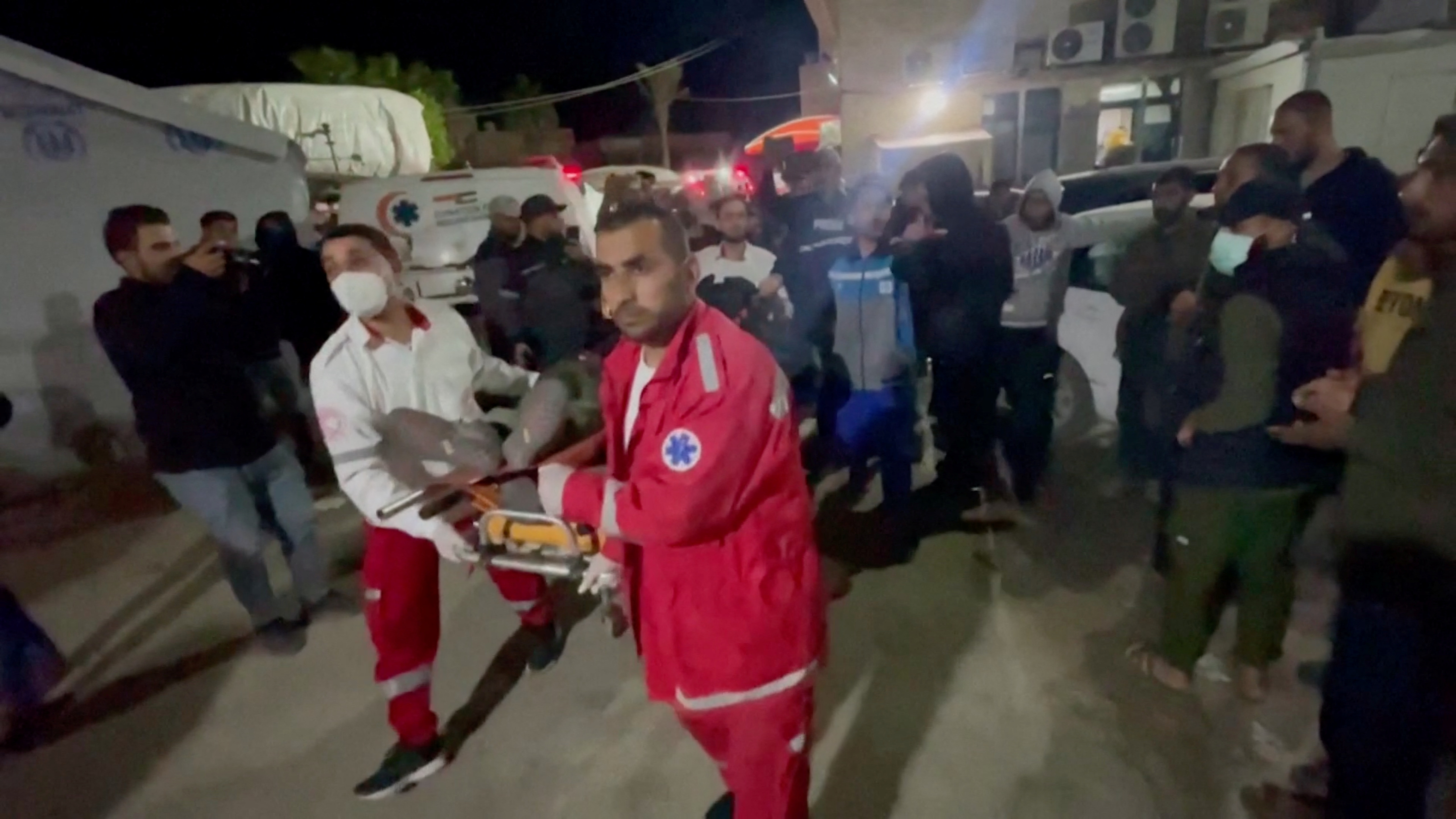 The body of a World Central Kitchen (WCK) worker is transported on a stretcher by paramedics in Deir al-Balah