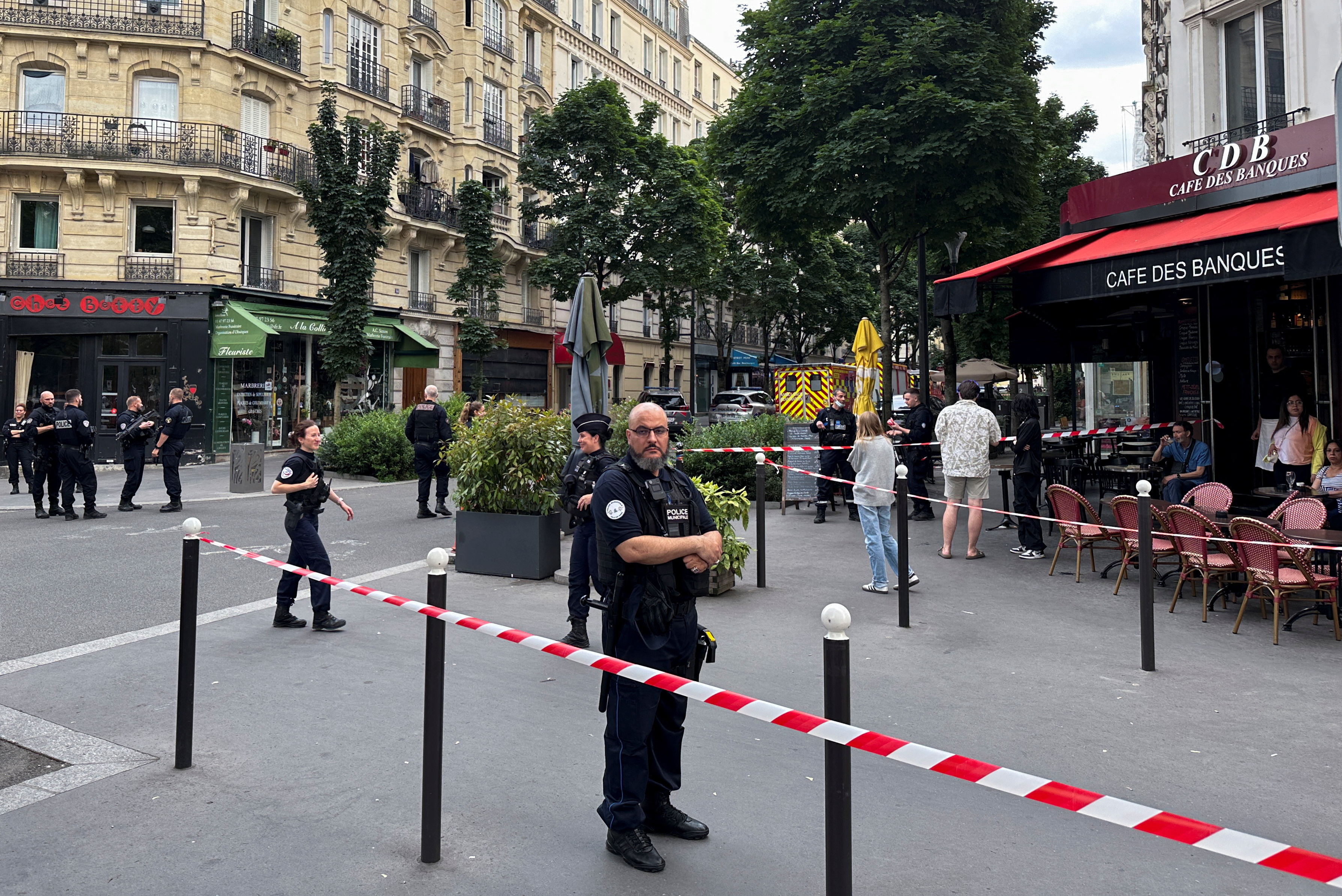 A police officer stands at the scene after a car hit people sitting on a terrace in front of a restaurant in Paris