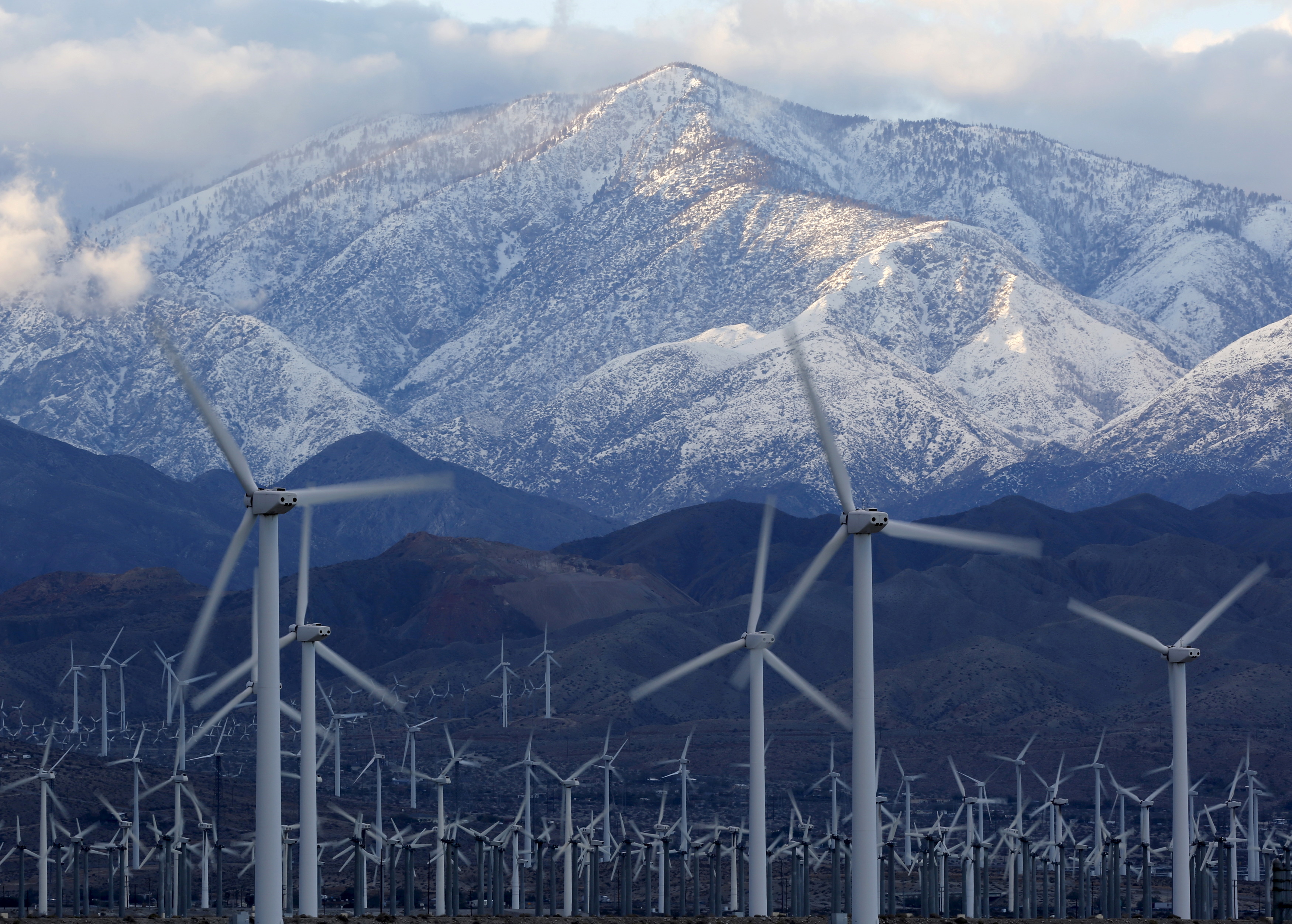 Snow is seen on the San Gorgonio Mountains behind a windmill farm in Palm Springs