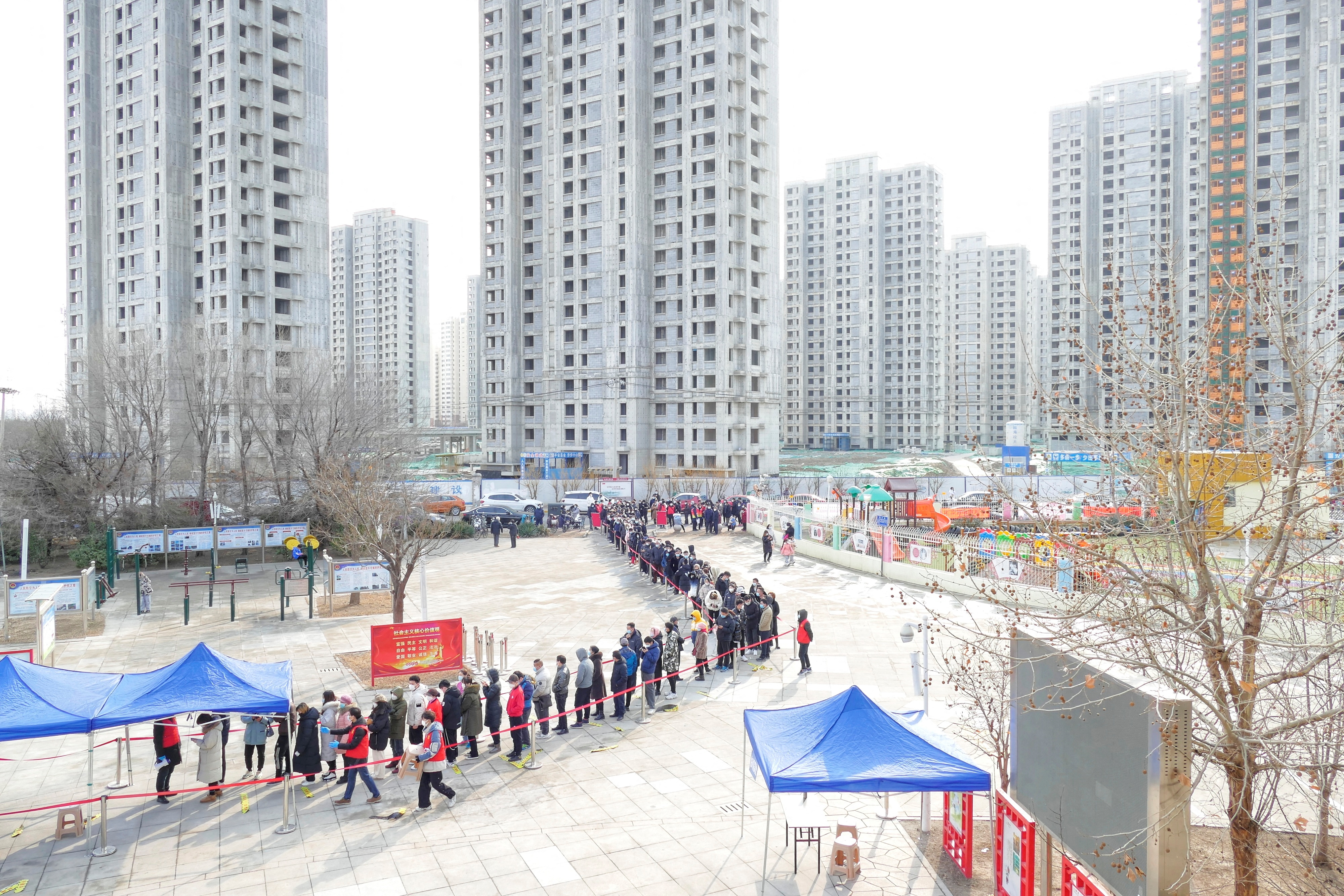 People line up for nucleic acid testing after local cases of the Omicron variant were detected in Tianjin