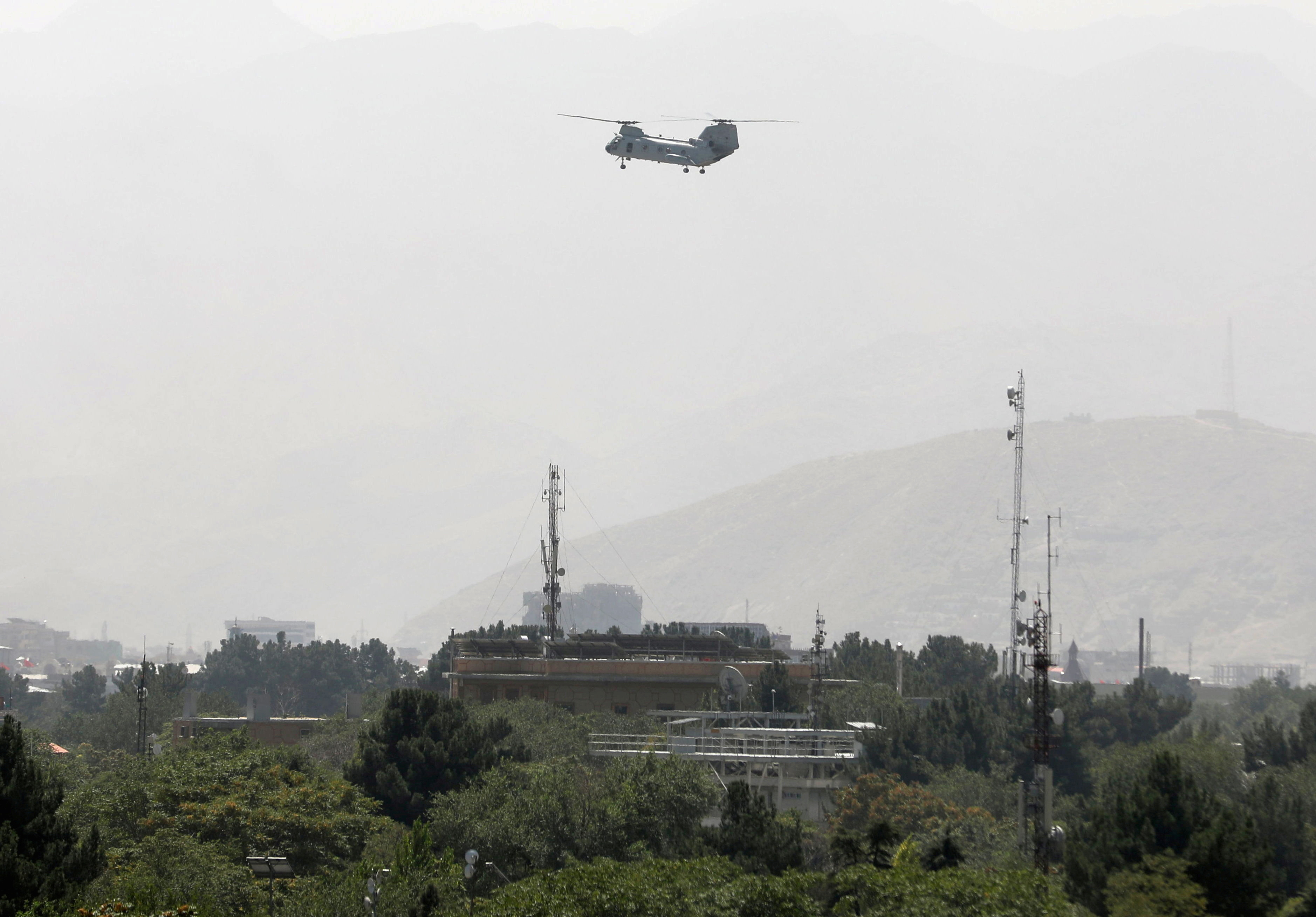 Military transport helicopter flies over Kabul