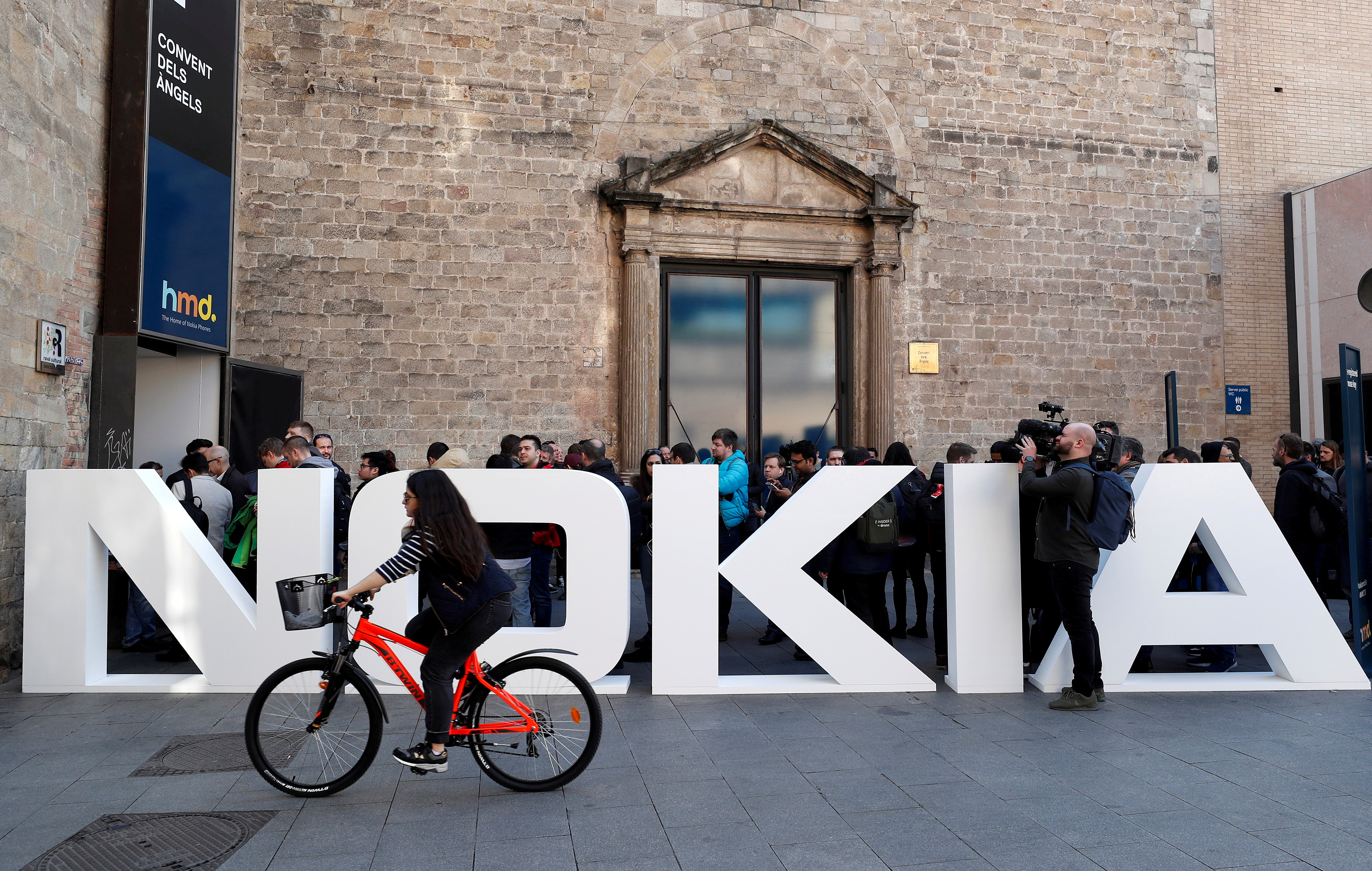 A cyclist rides past a Nokia logo during the Mobile World Congress in Barcelona, Spain February 25, 2018. REUTERS/Yves Herman