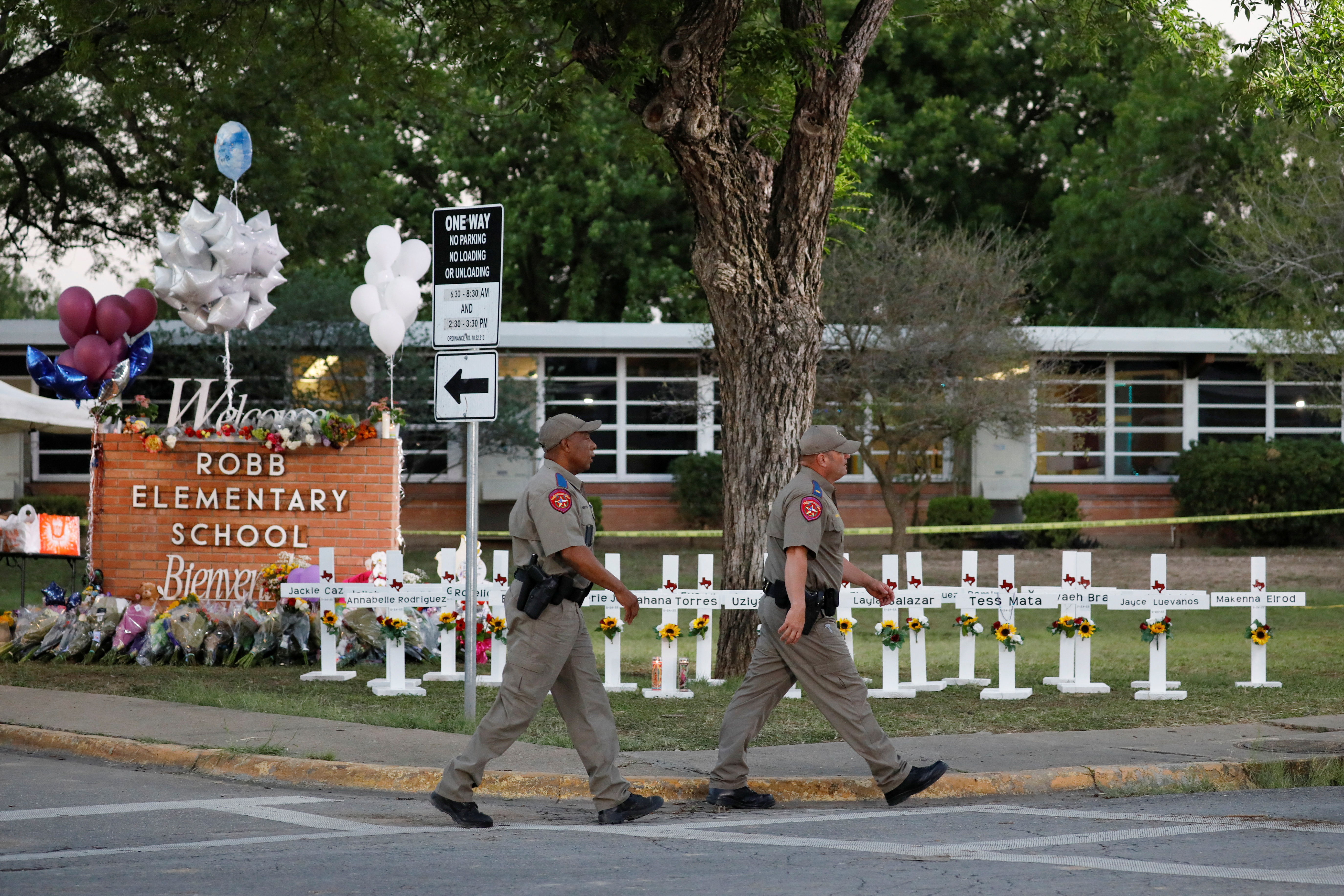 Texas Department of Public Safety officers walk past a memorial, after mass shooting at Robb Elementary School in Uvalde