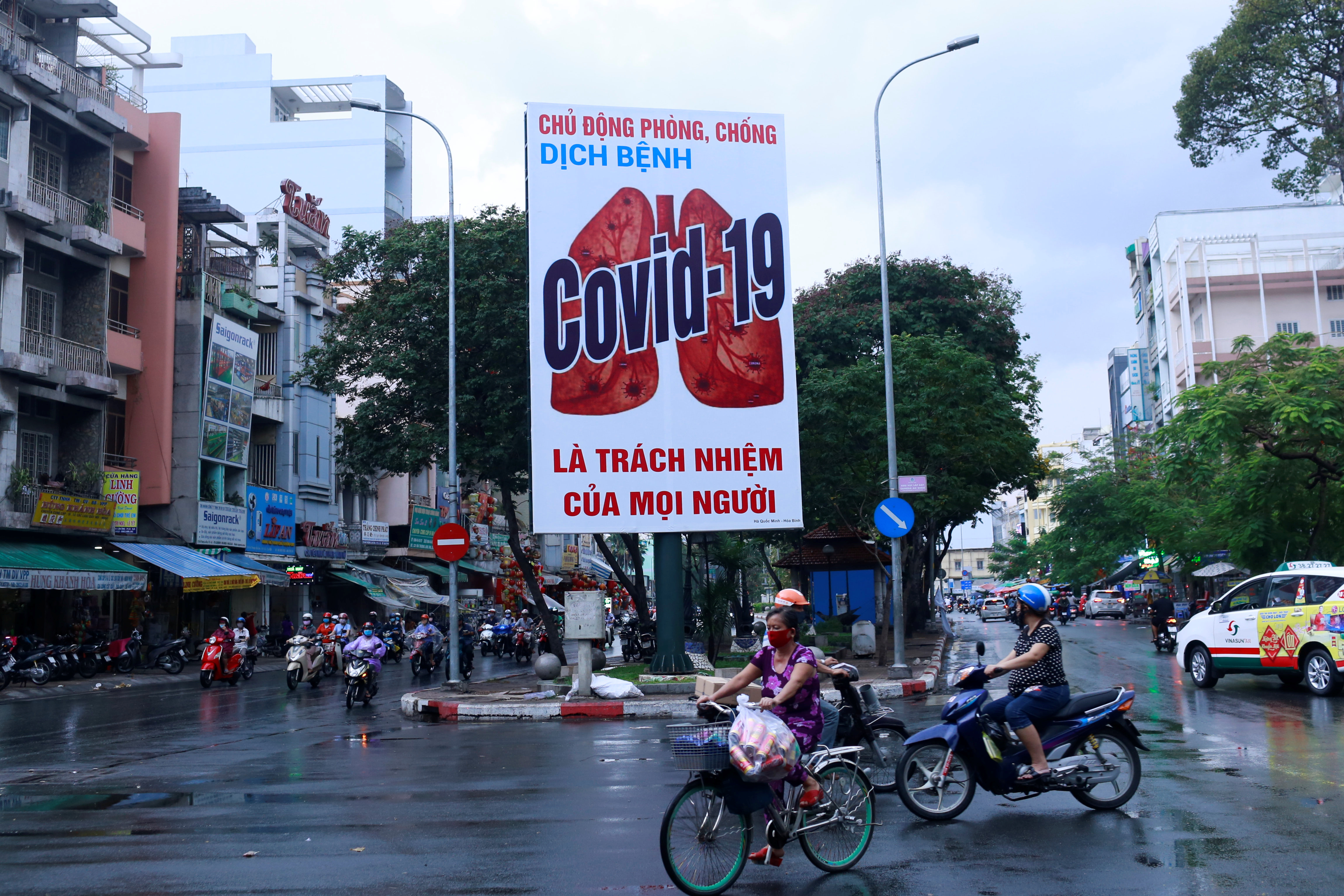 Motorbikes drive past a billboard warning against the coronavirus disease (COVID-19) after the government eased nationwide lockdown during the outbreak in Ho Chi Minh, Vietnam, April 25, 2020. REUTERS/Yen Duong