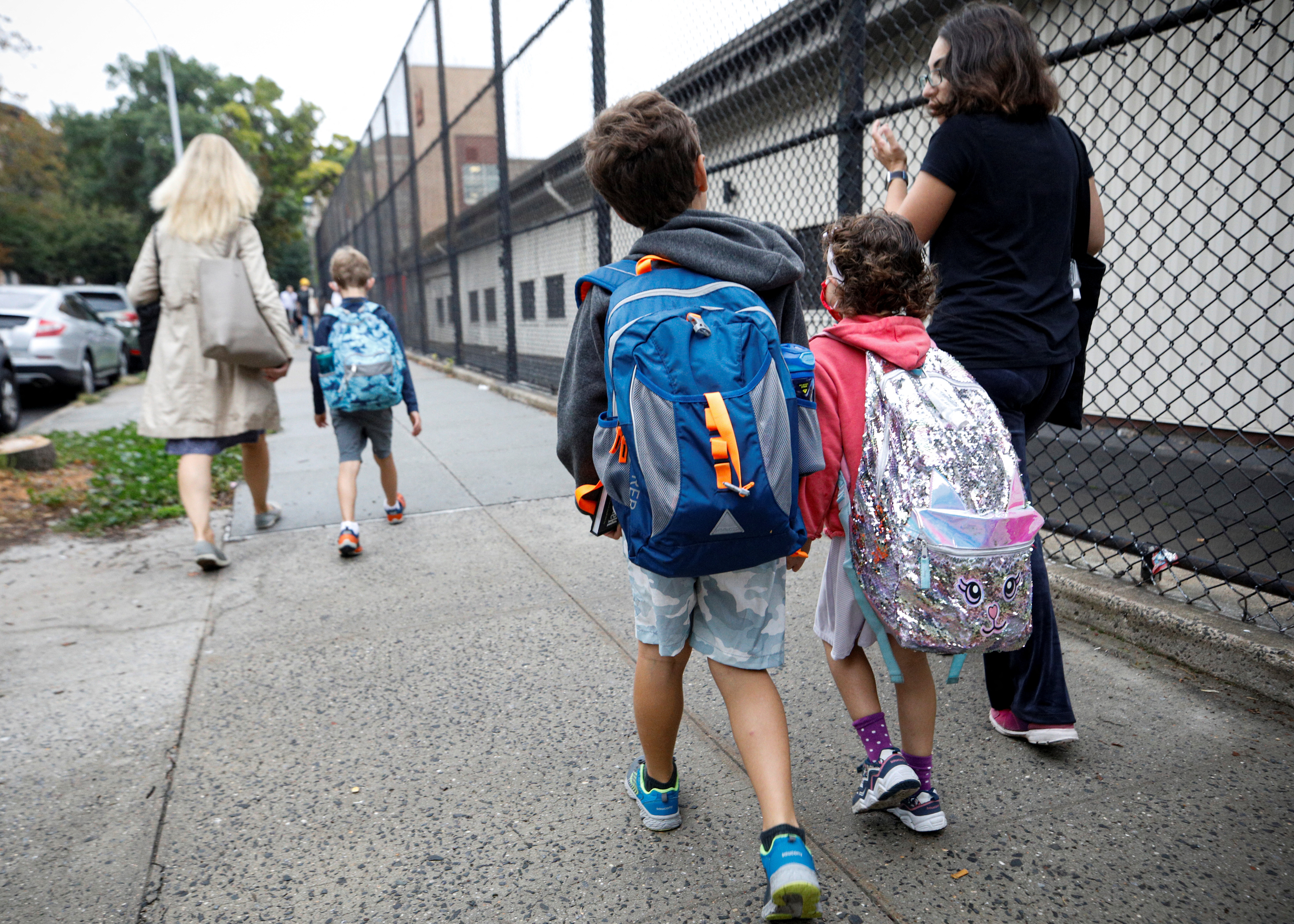 Parents walk with children to school, amid the coronavirus disease (COVID-19) pandemic in Brooklyn, New York, U.S.  October 4, 2021.  REUTERS/Brendan McDermid
