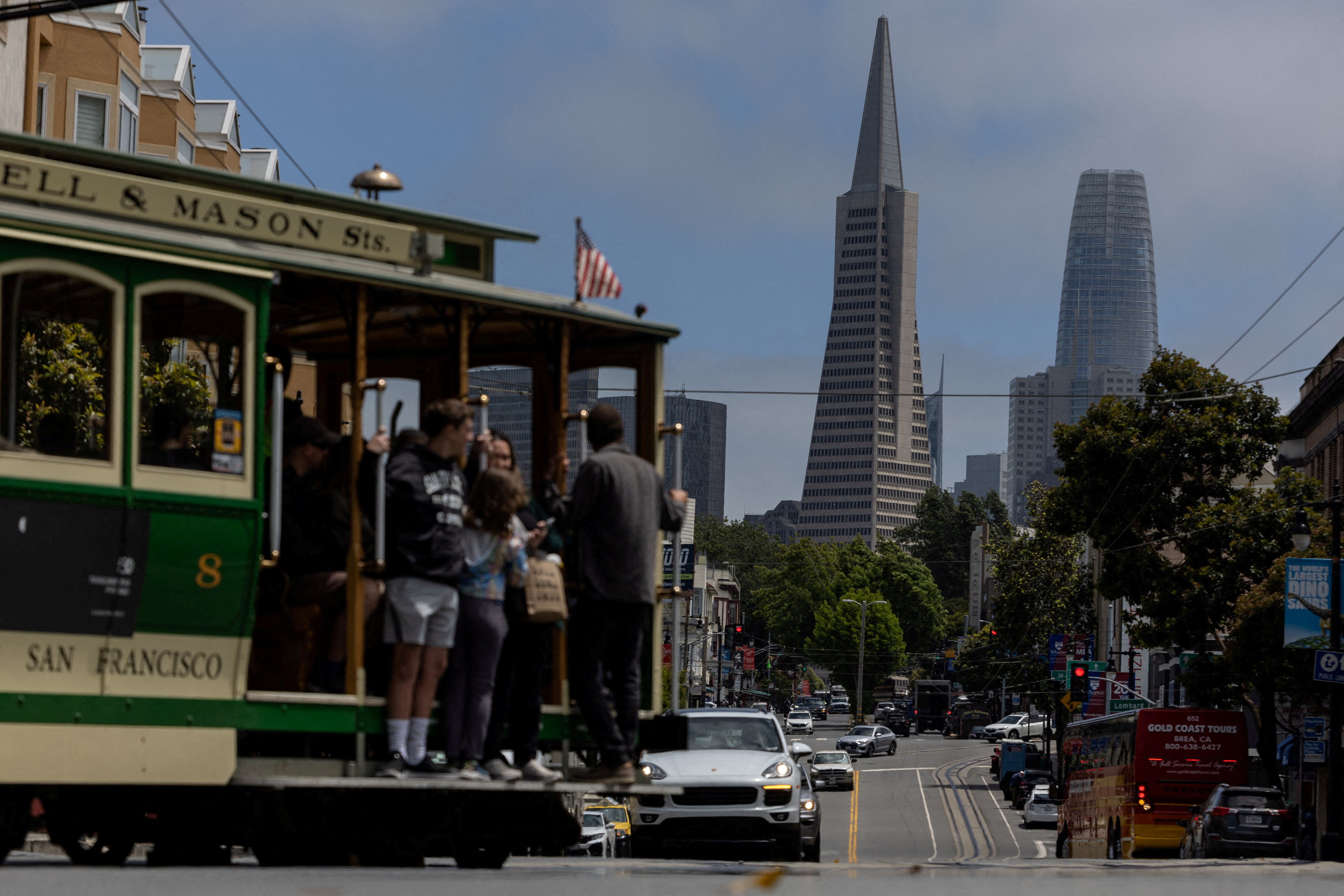 The Transamerica Pyramid building is seen as tourists ride a cable car in downtown San Francisco