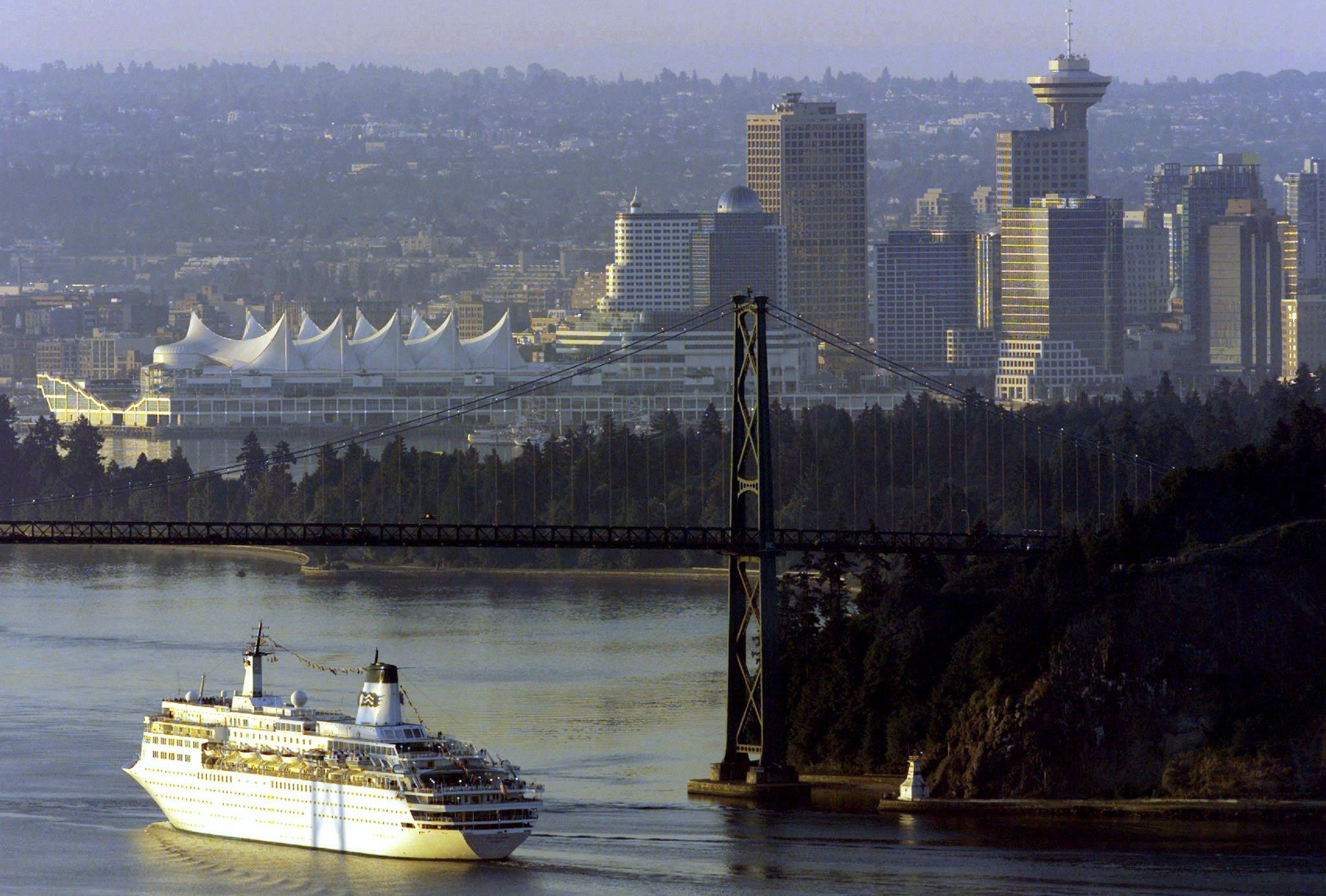 A cruise ship arriving from Alaska makes its way past Stanley Park and under the Lions Gate Bridge as it sails into Vancouver in the early morning of July 27, 1998. REUTERS/Mike Blake