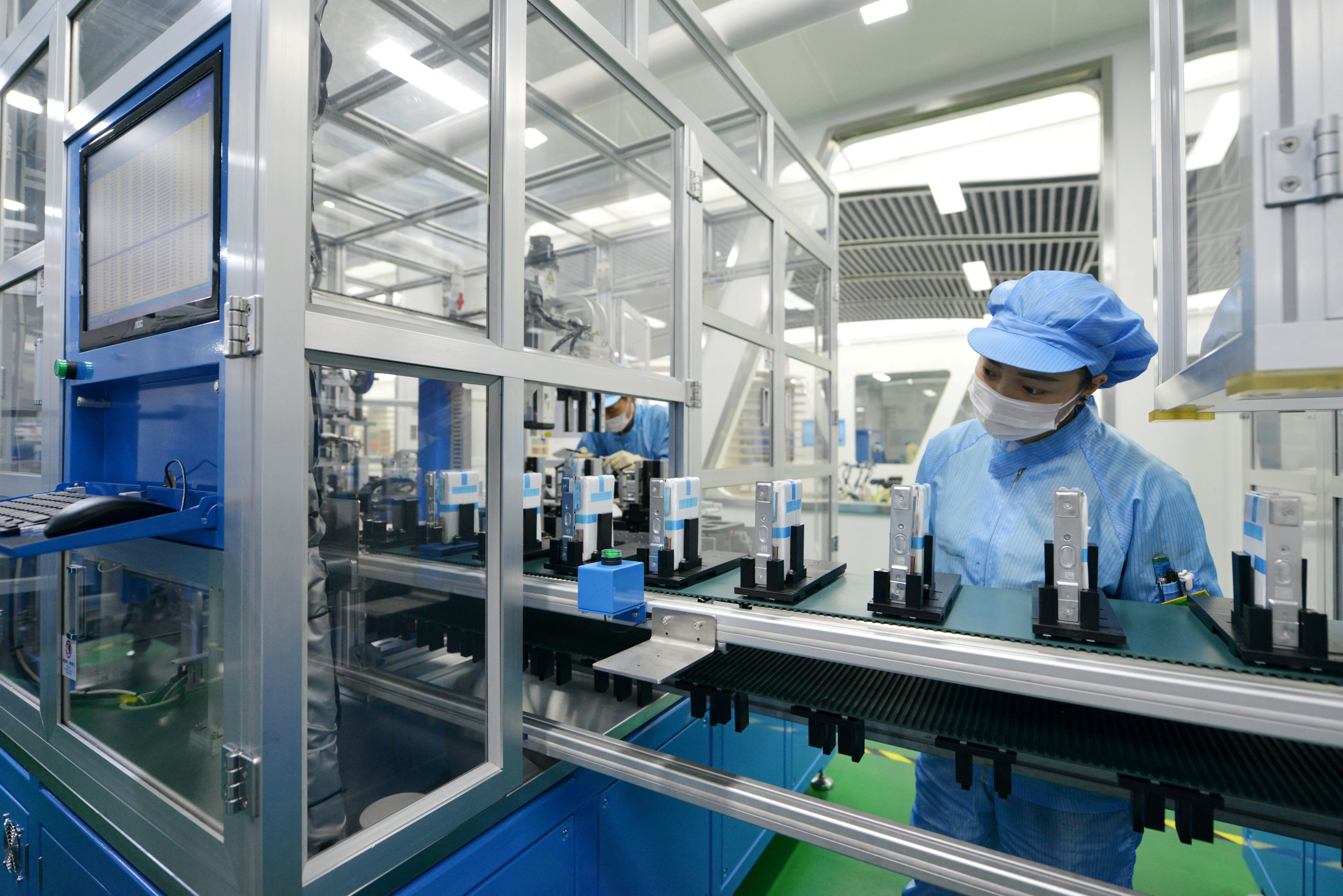 Workers are seen at the production line of lithium-ion batteries for electric vehicles (EV) at a factory in Huzhou