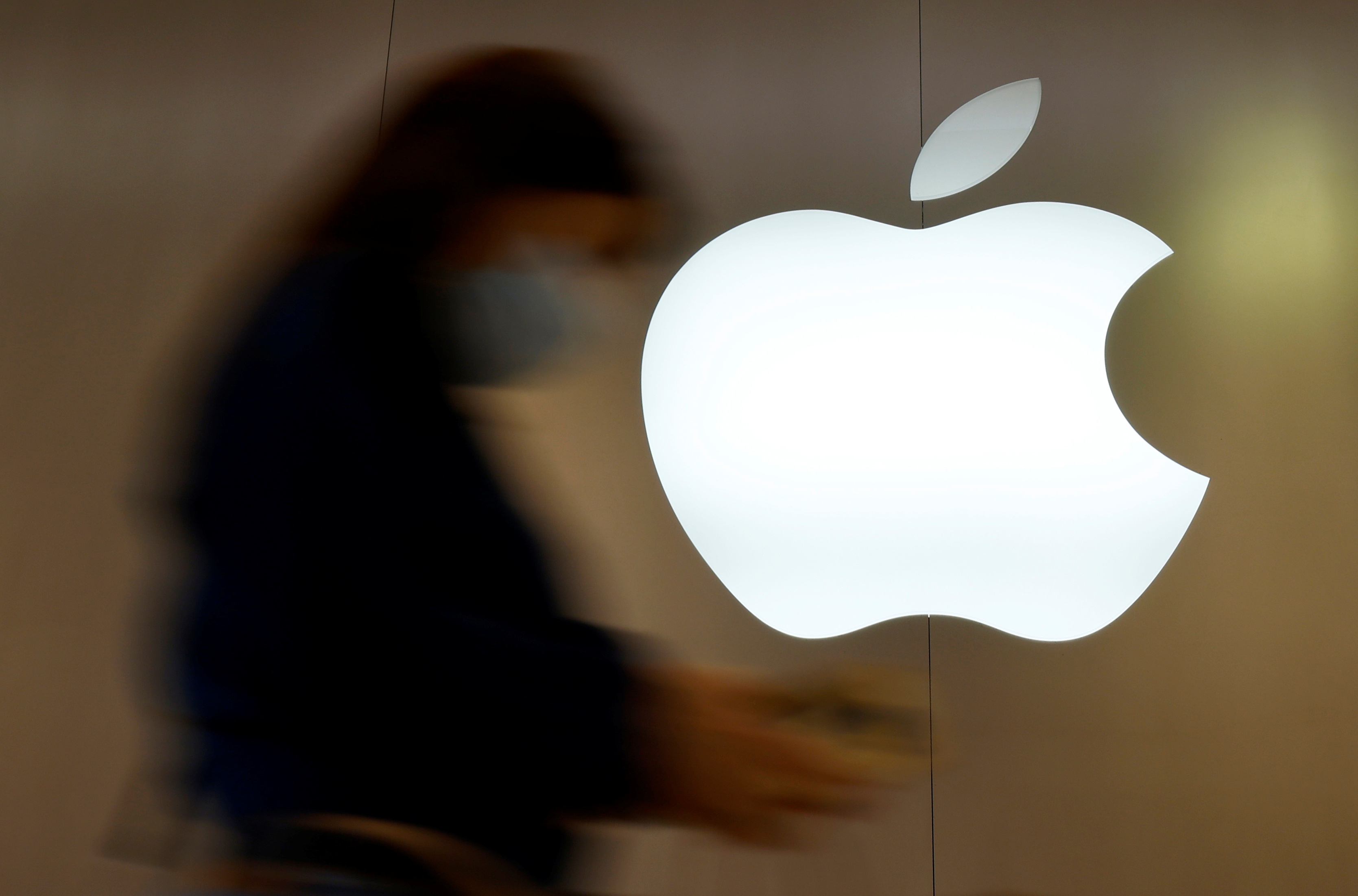 A woman walks past an Apple logo in front of an Apple store in Saint-Herblain near Nantes, France, September 16, 2021.  REUTERS/Stephane Mahe/Files