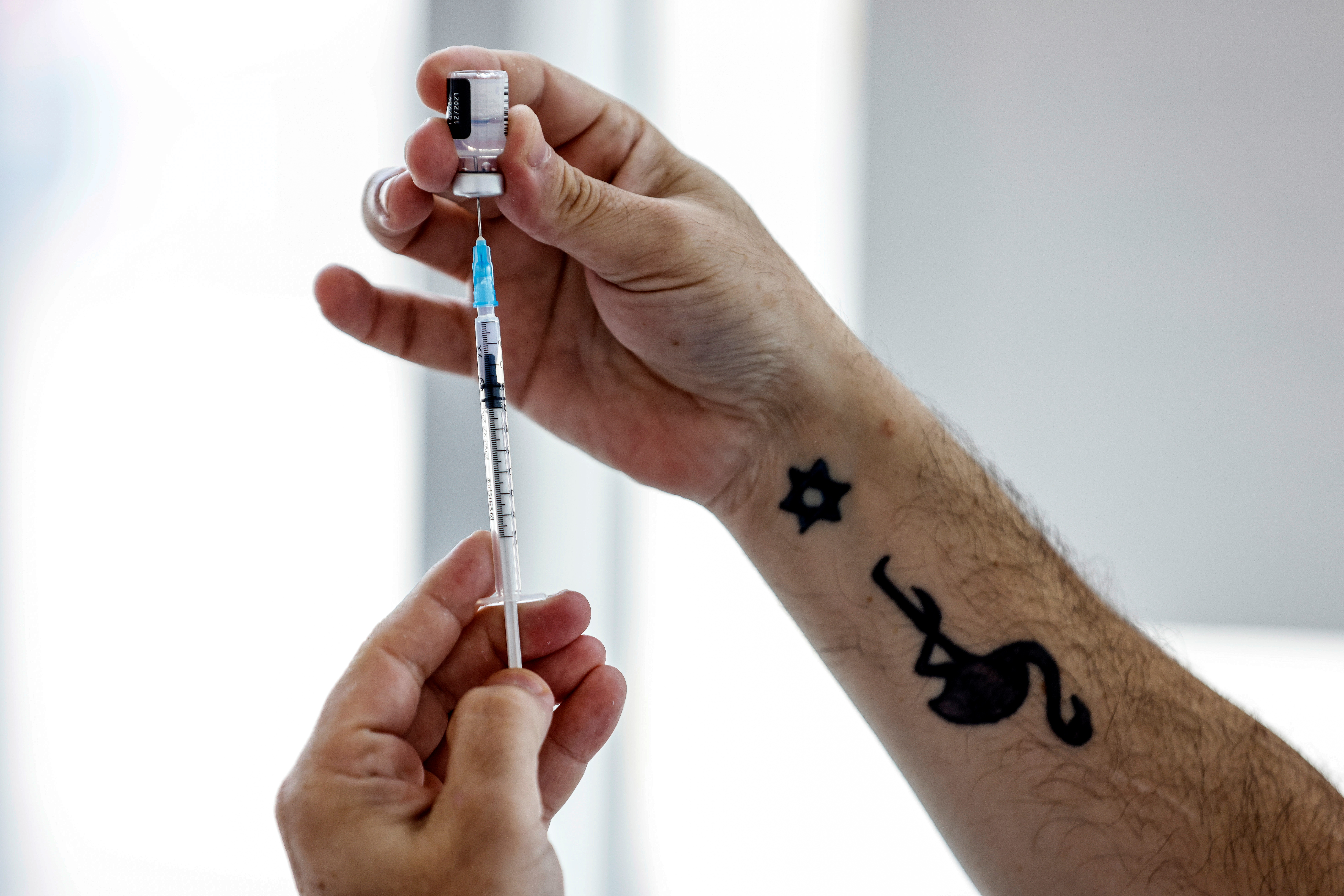 A medical worker prepares to administer a patient's third dose of the coronavirus disease (COVID-19) vaccine