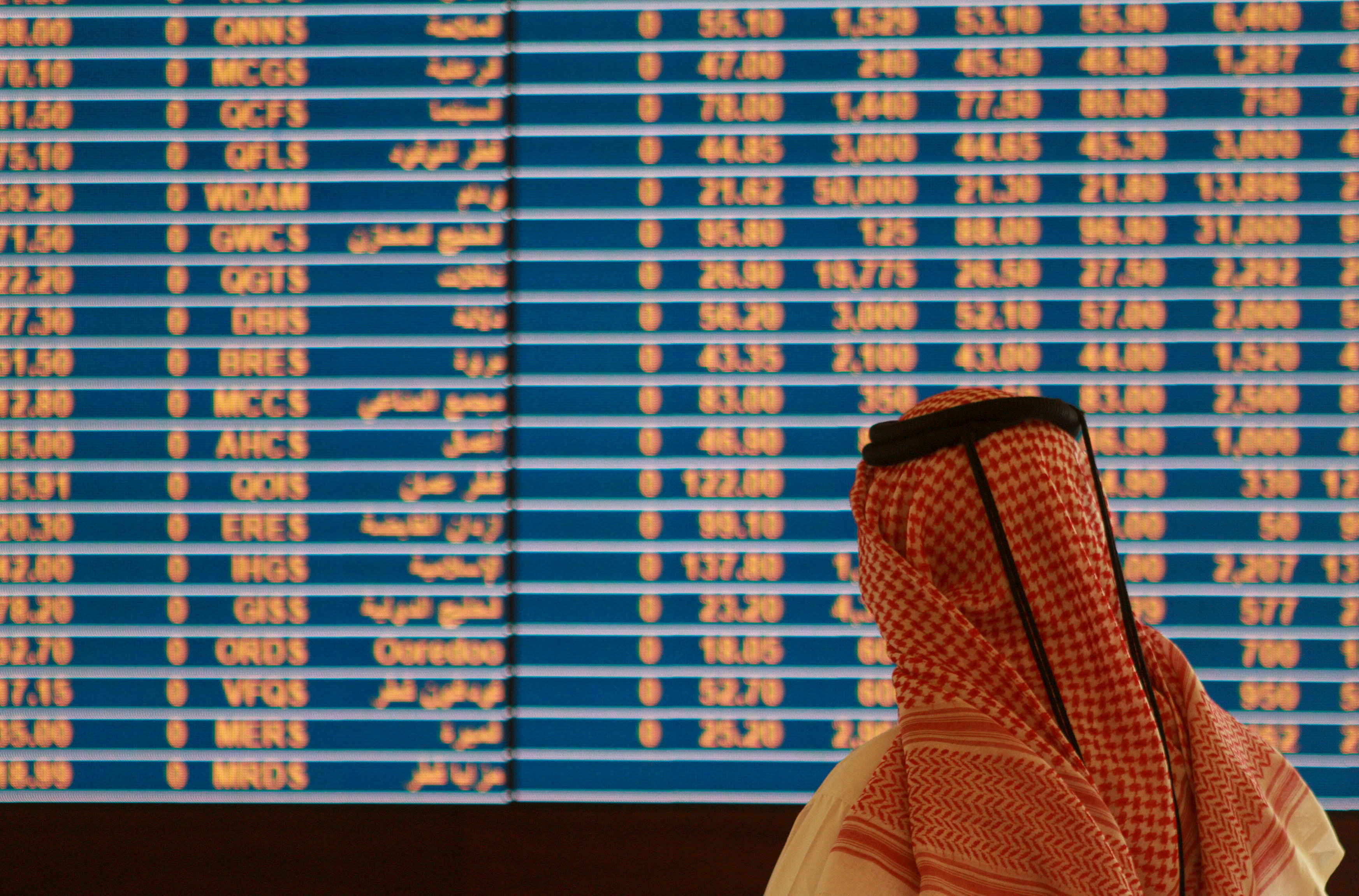 Trader watches an electronic share price display at the Doha Stock Exchange in Doha