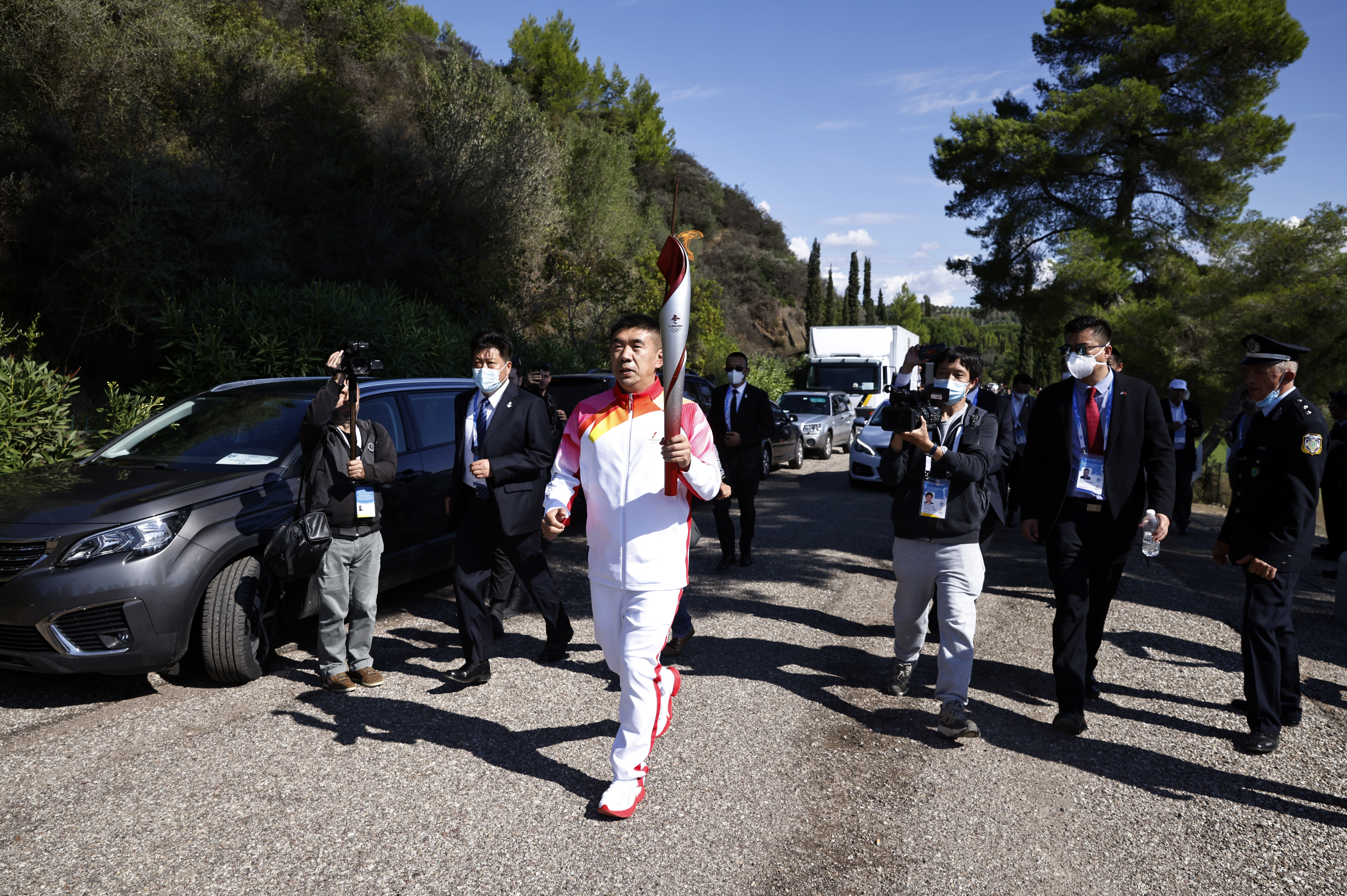 Winter Olympics - Lighting ceremony of the Olympic flame for the Beijing 2022 Winter Olympics - Ancient Olympia, Olympia, Greece - October 18, 2021 Second torchbearer, former Chinese track speed skater Li Jiajun runs with the Olympic flame during the Olympic flame lighting ceremony for the Beijing 2022 Winter Olympics REUTERS/Alkis Konstantinidis