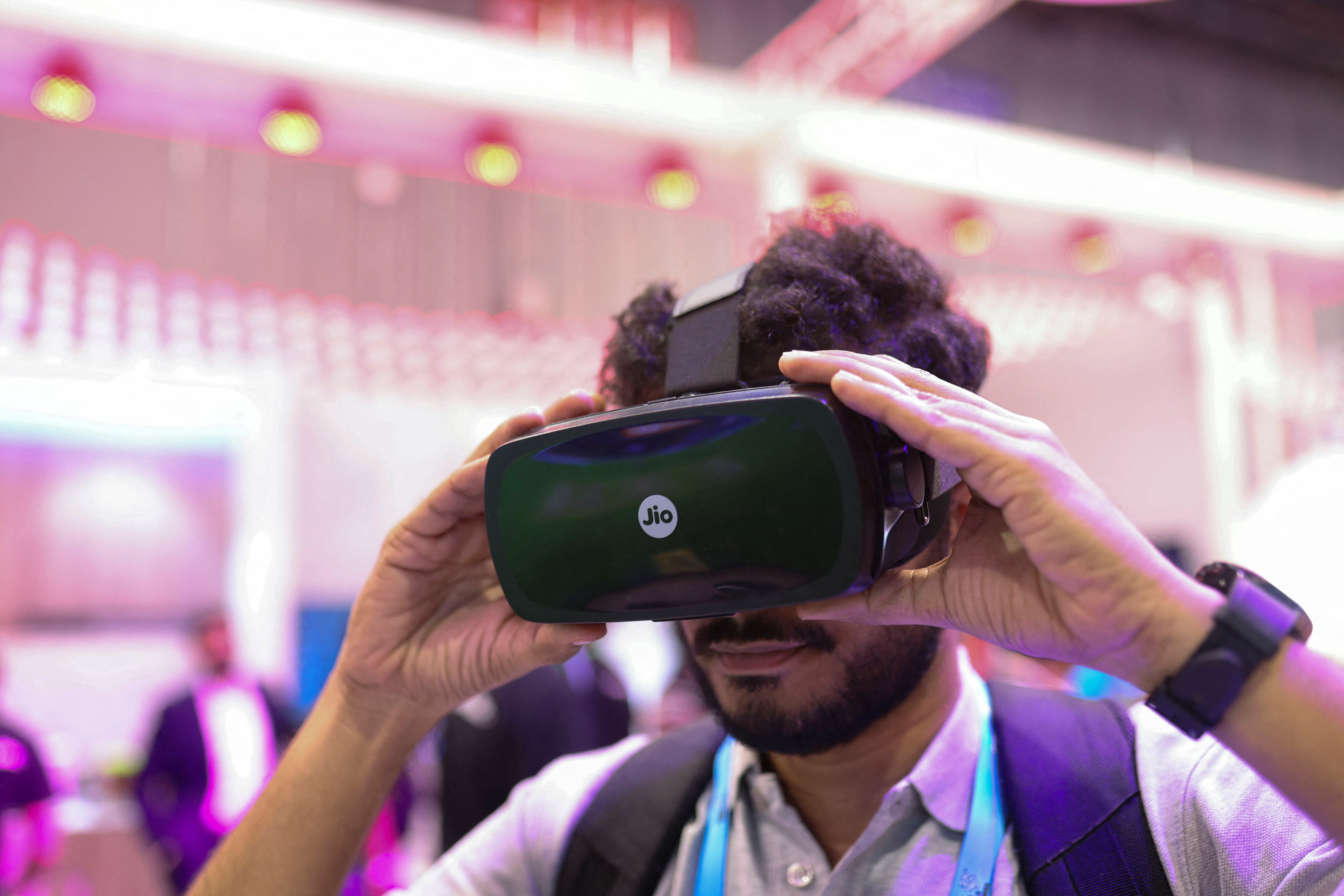 A man uses JioDive, a smartphone based virtual reality headset at the Jio exhibitor stall at the India Mobile Congress 2023 at Pragati Maidan in New Delhi