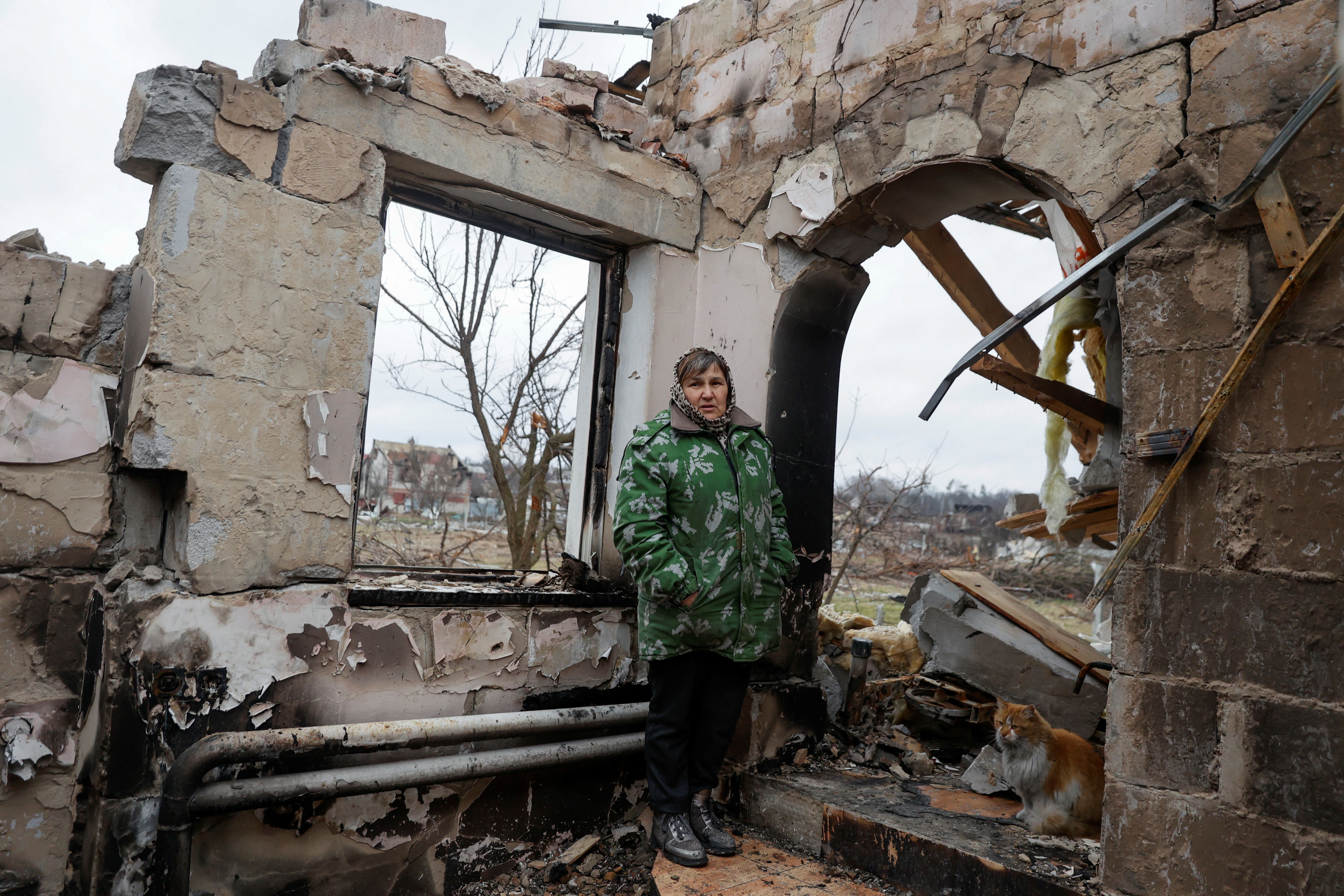 A local woman Maria stands on remains of her house destroyed by heavy shelling and airstrikes in Chernihiv