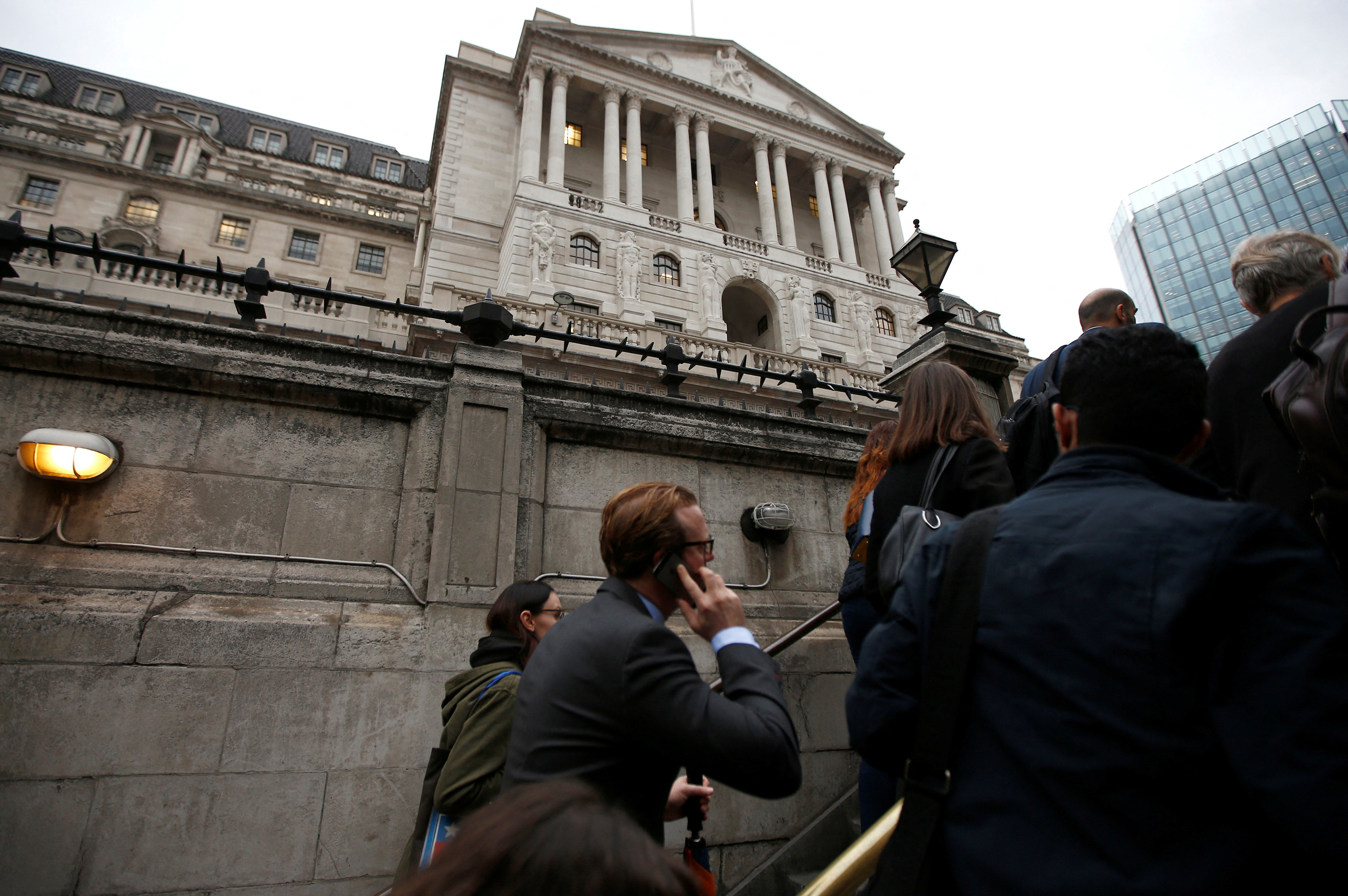 Commuters exit the underground in front of the Bank of England in London