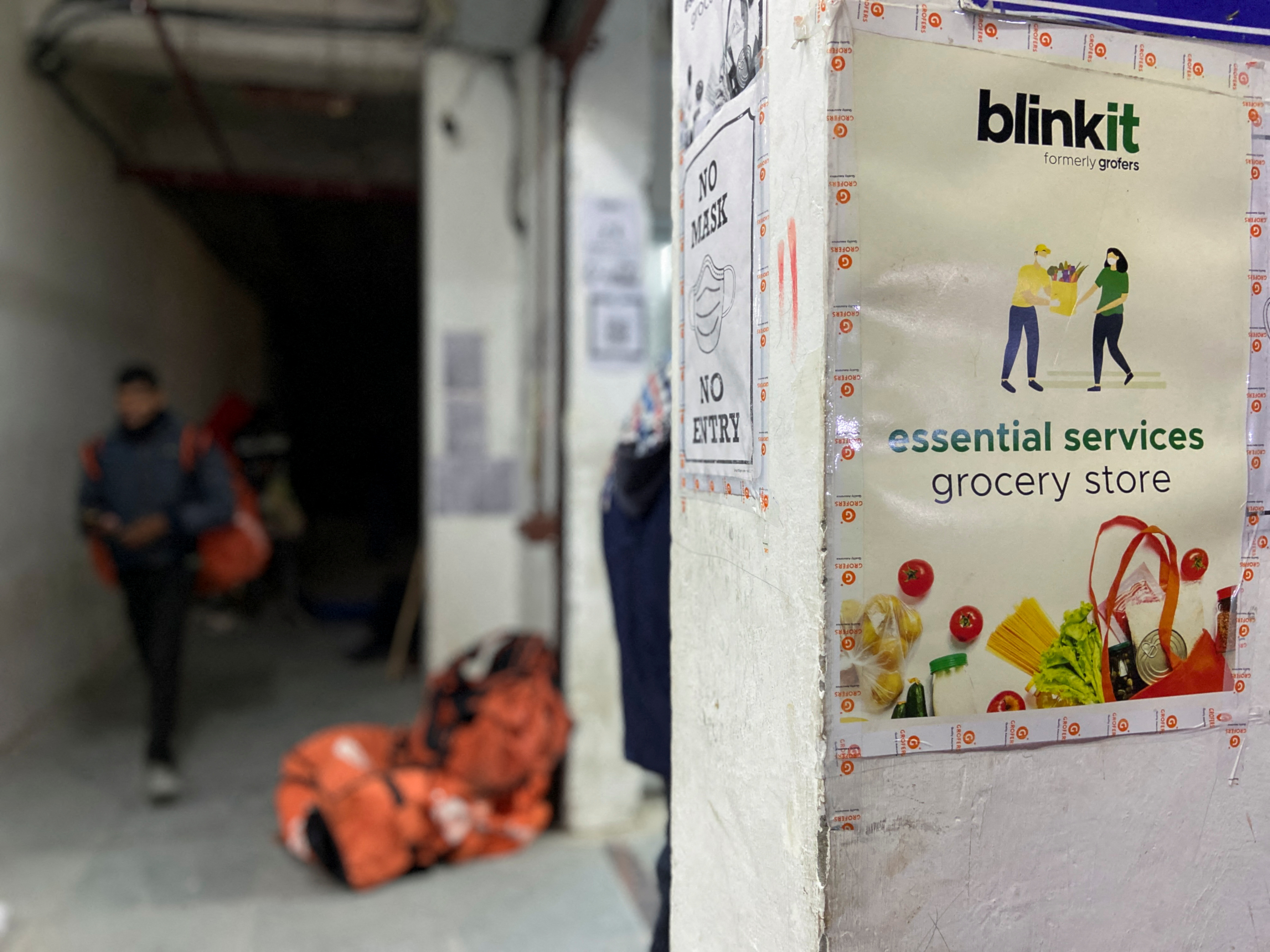 A delivery person leaves a dark store of the SoftBank-funded Blinkit in New Delhi