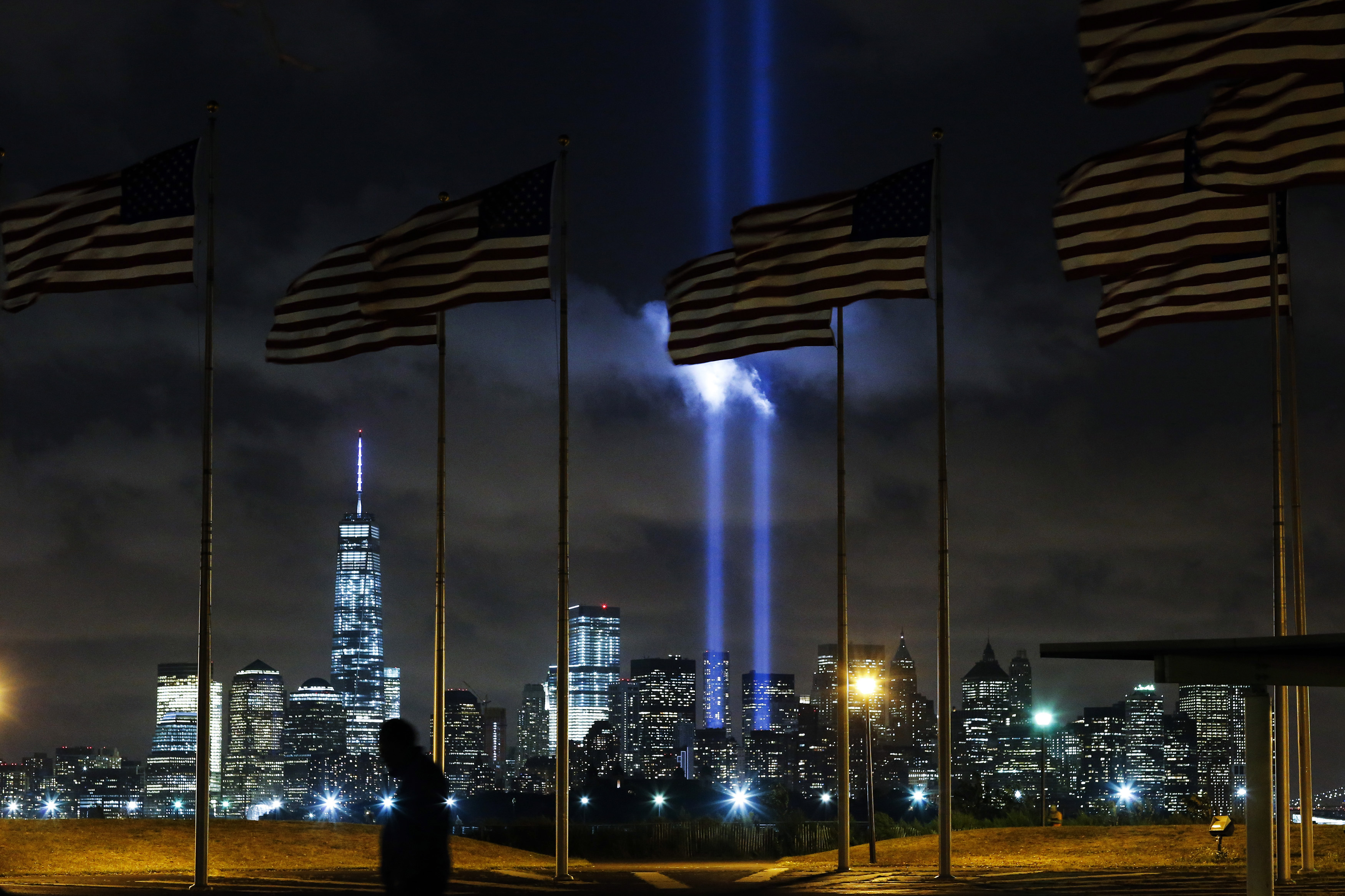 Man walks past as the Tribute in Light is illuminated on the skyline of lower Manhattan during events marking the 13th anniversary of the 9/11 attacks on the World Trade Center in New York