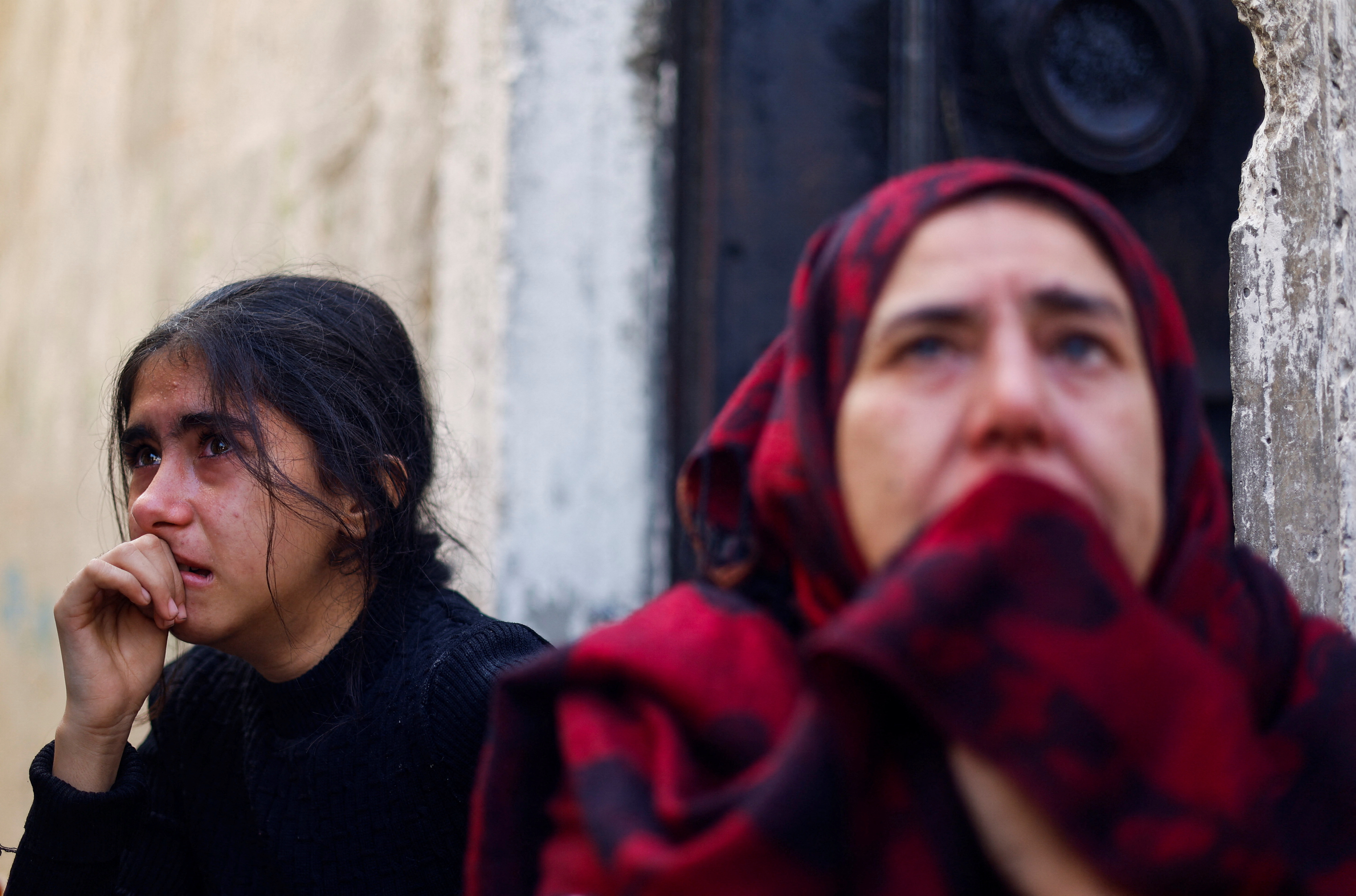 A Palestinian girl and woman react at the site of an Israeli strike on a house, after a temporary truce between Hamas and Israel expired, in Khan Younis