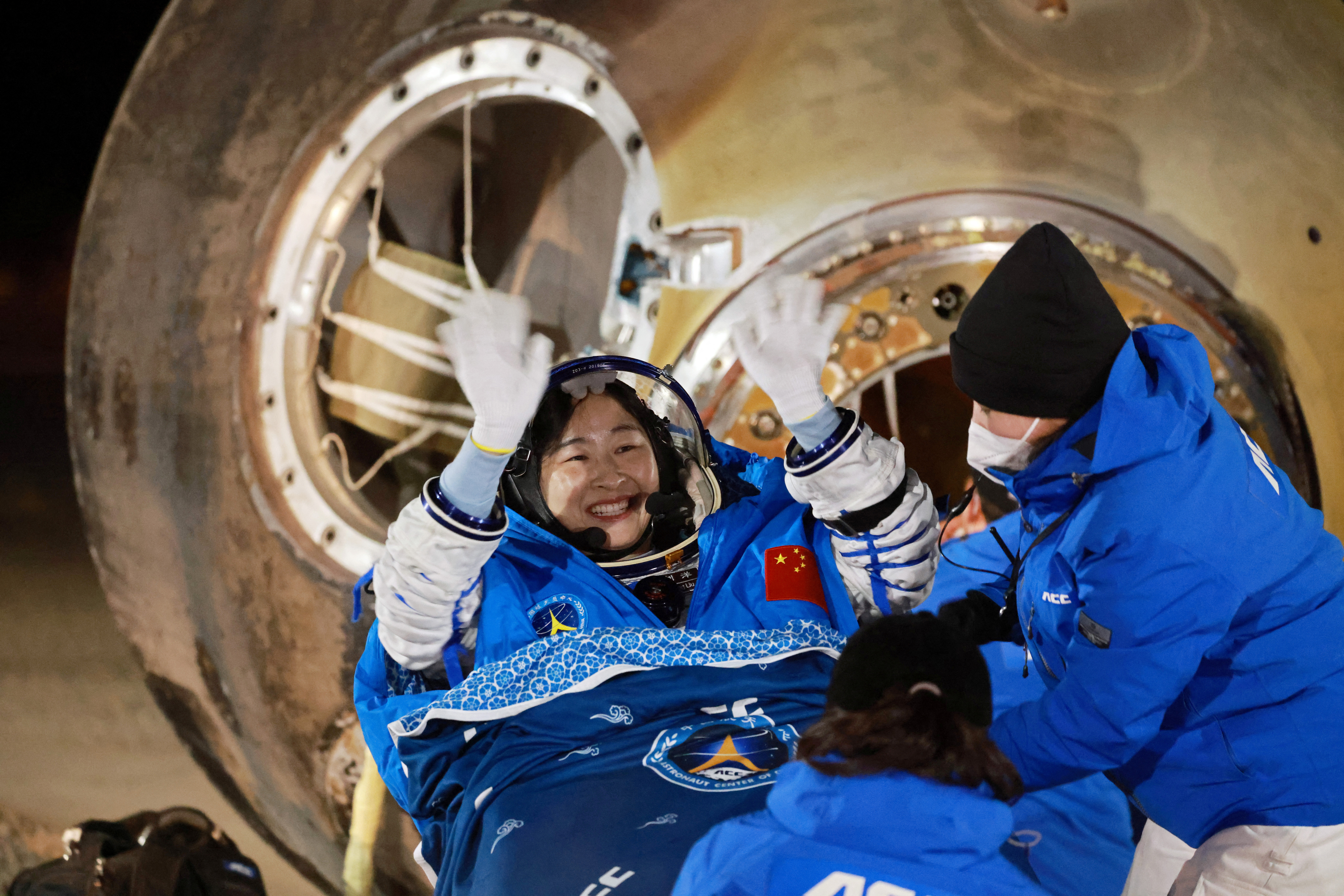 Astronaut Liu Yang waves as she is out of a return capsule of the Shenzhou-14 spacecraft