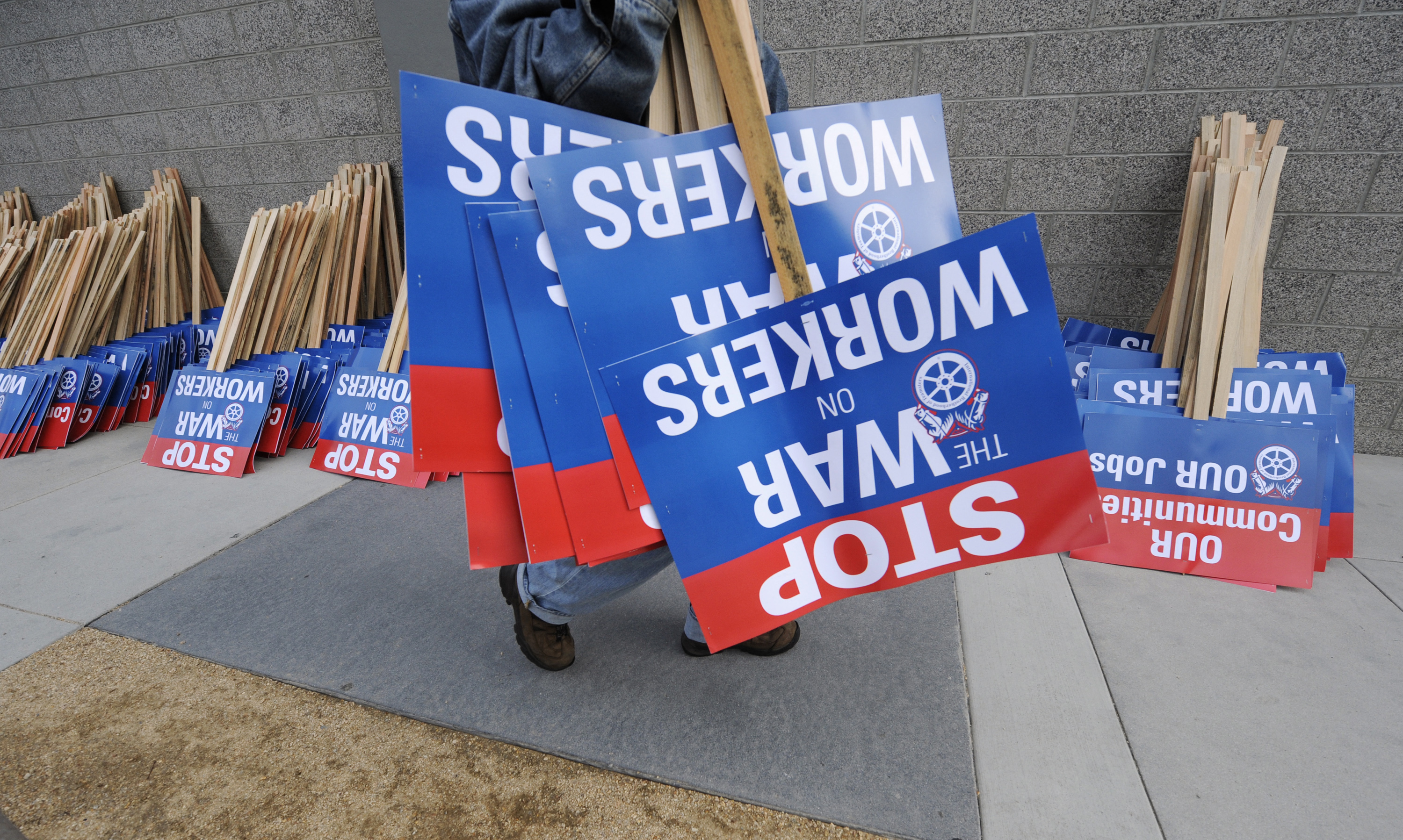 Participants distribute signs during a march and rally by labor union supporters in Los Angeles