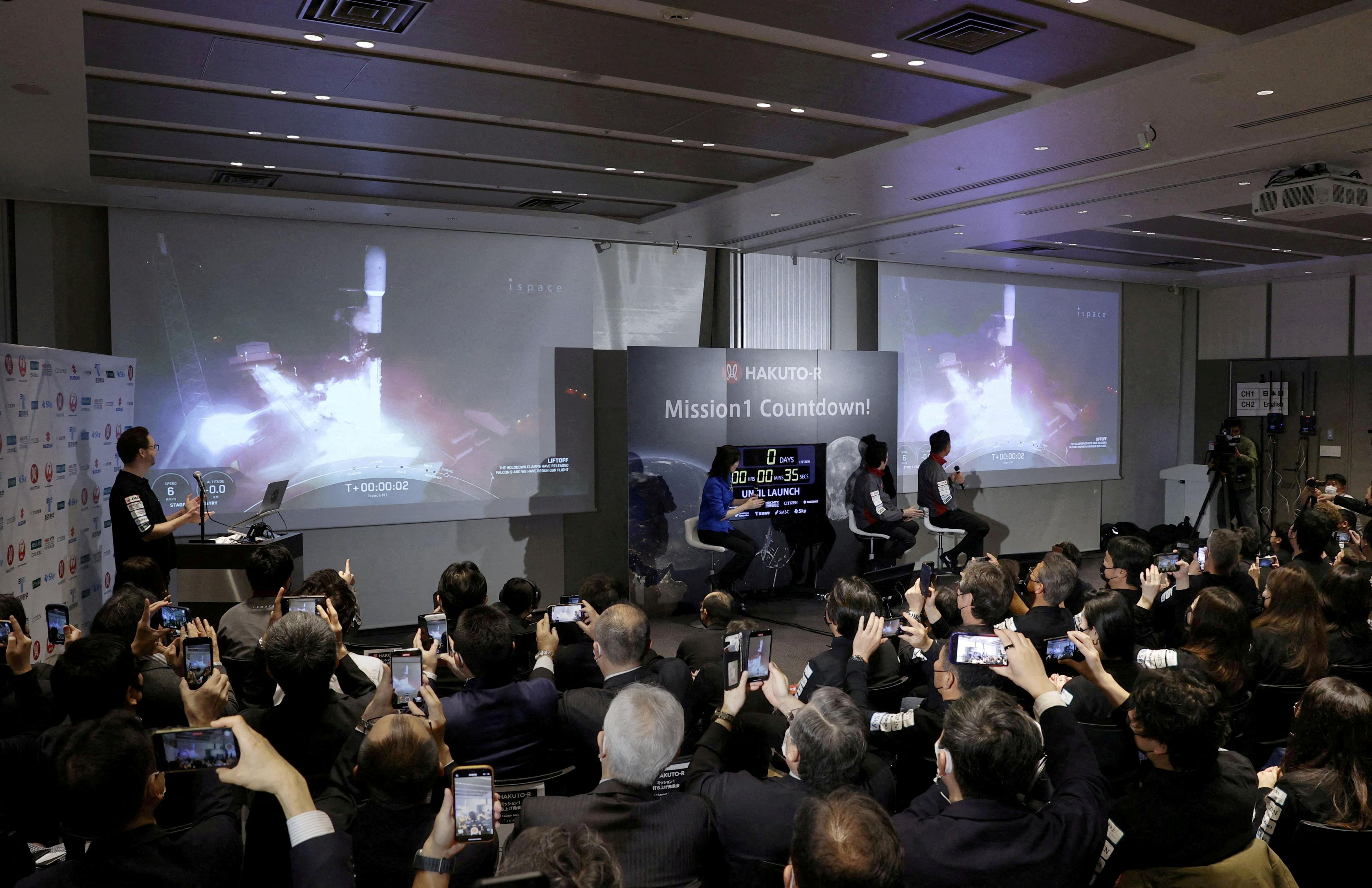 Officials of ispace Inc's HAKUTO-R mission look at live broadcasting of the launch of a SpaceX Falcon 9 rocket in Tokyo