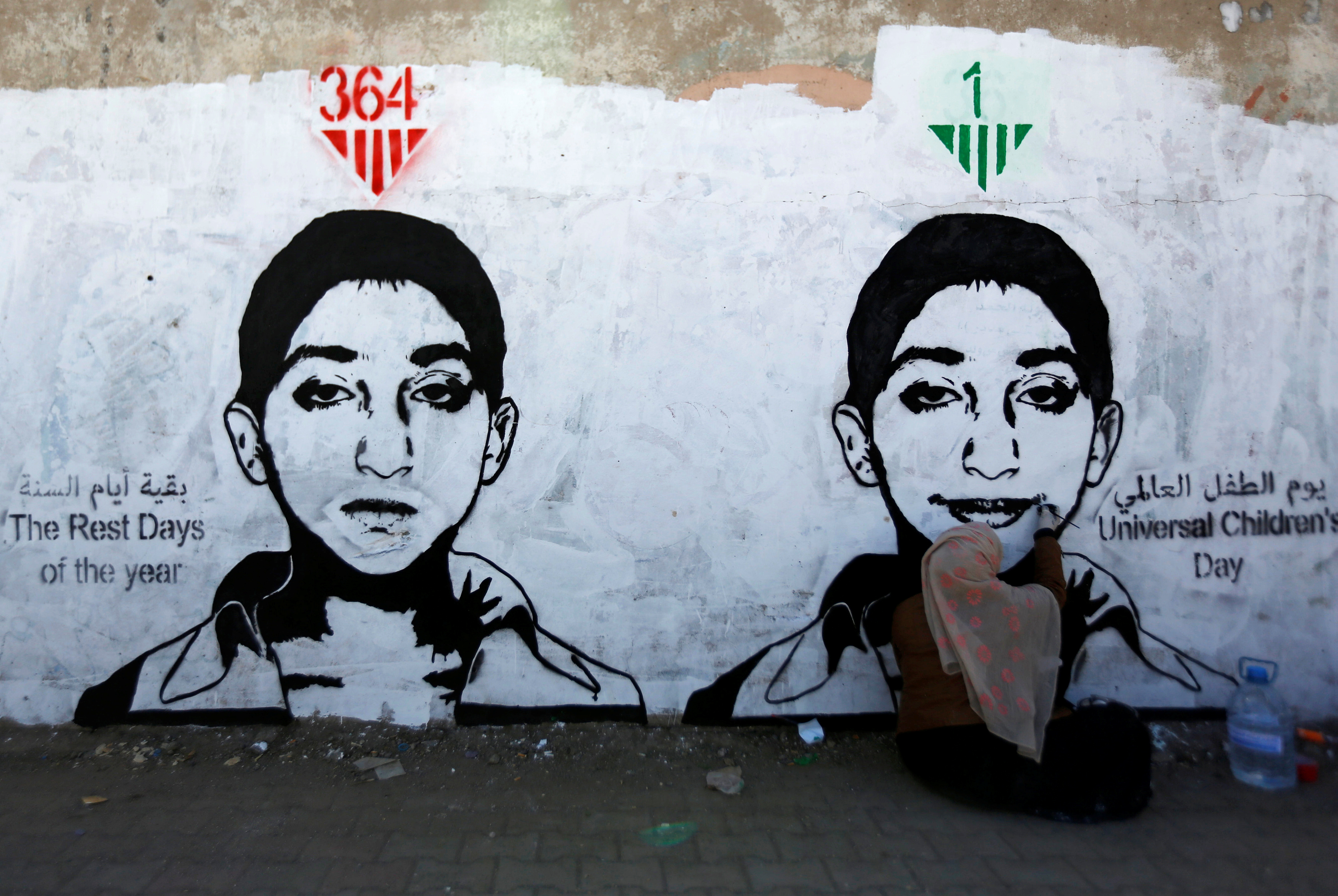 Artist Haifa Subay paints a mural about children's suffering in the time of war as part of the 'Silent Victims' campaign in Sanaa