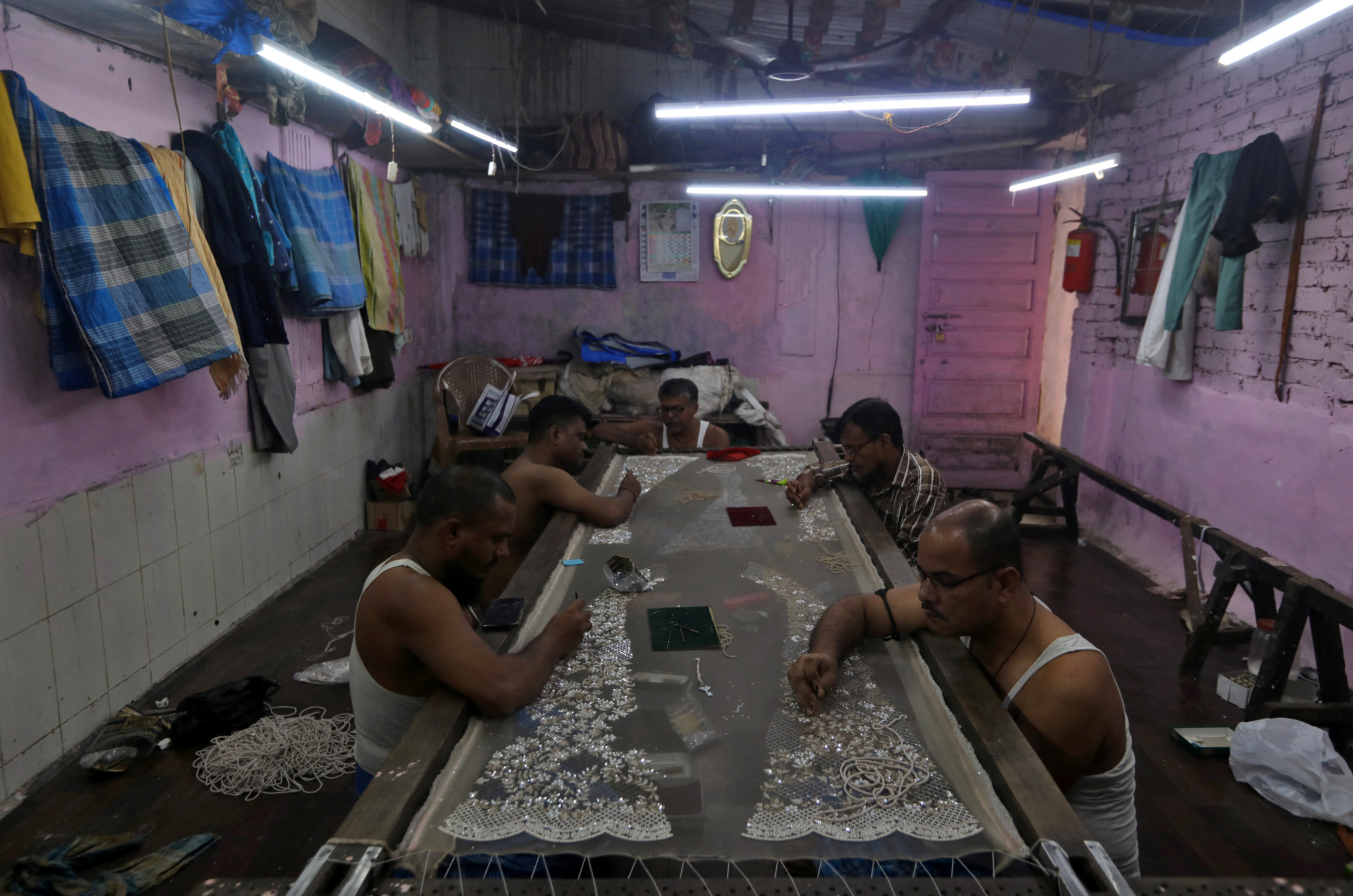 Artisans embroider a cloth inside a workshop in Dharavi, Mumbai