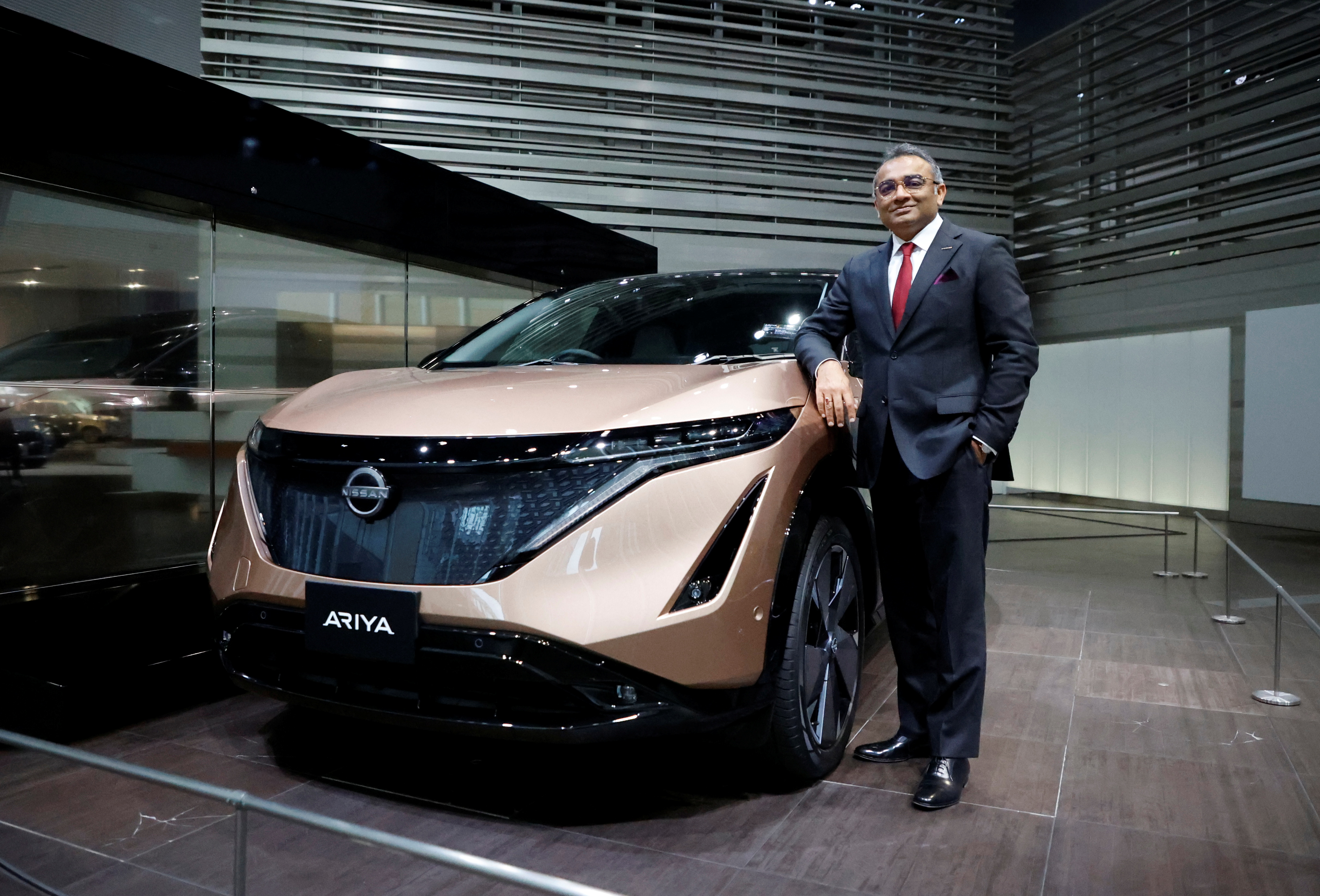 Nissan COO Ashwani Gupta poses with Ariya all-electric SUV after an interview with Reuters at its showroom in Yokohama