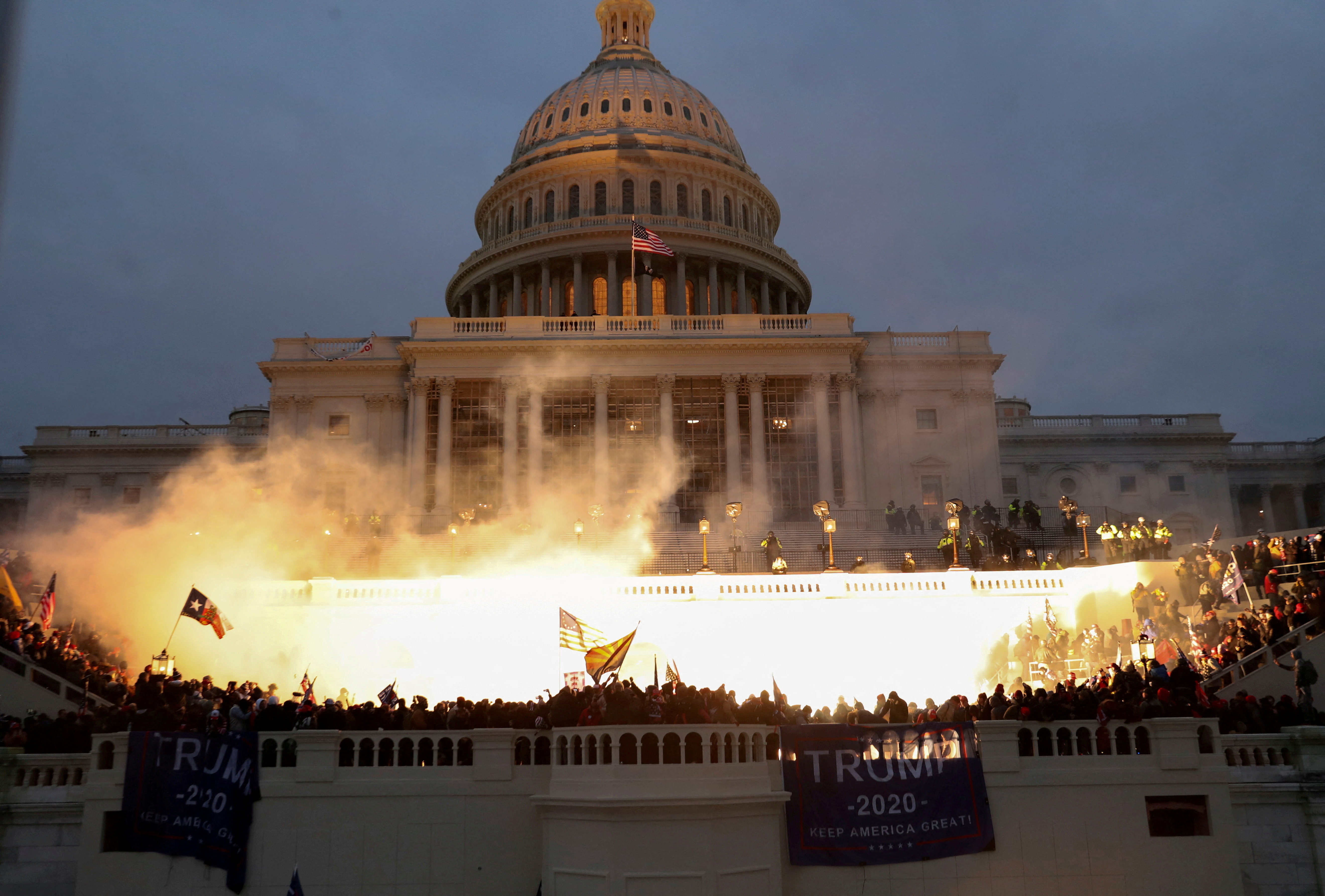 An explosion caused by a police munition is seen while supporters of former president Trump gather in front of the U.S. Capitol