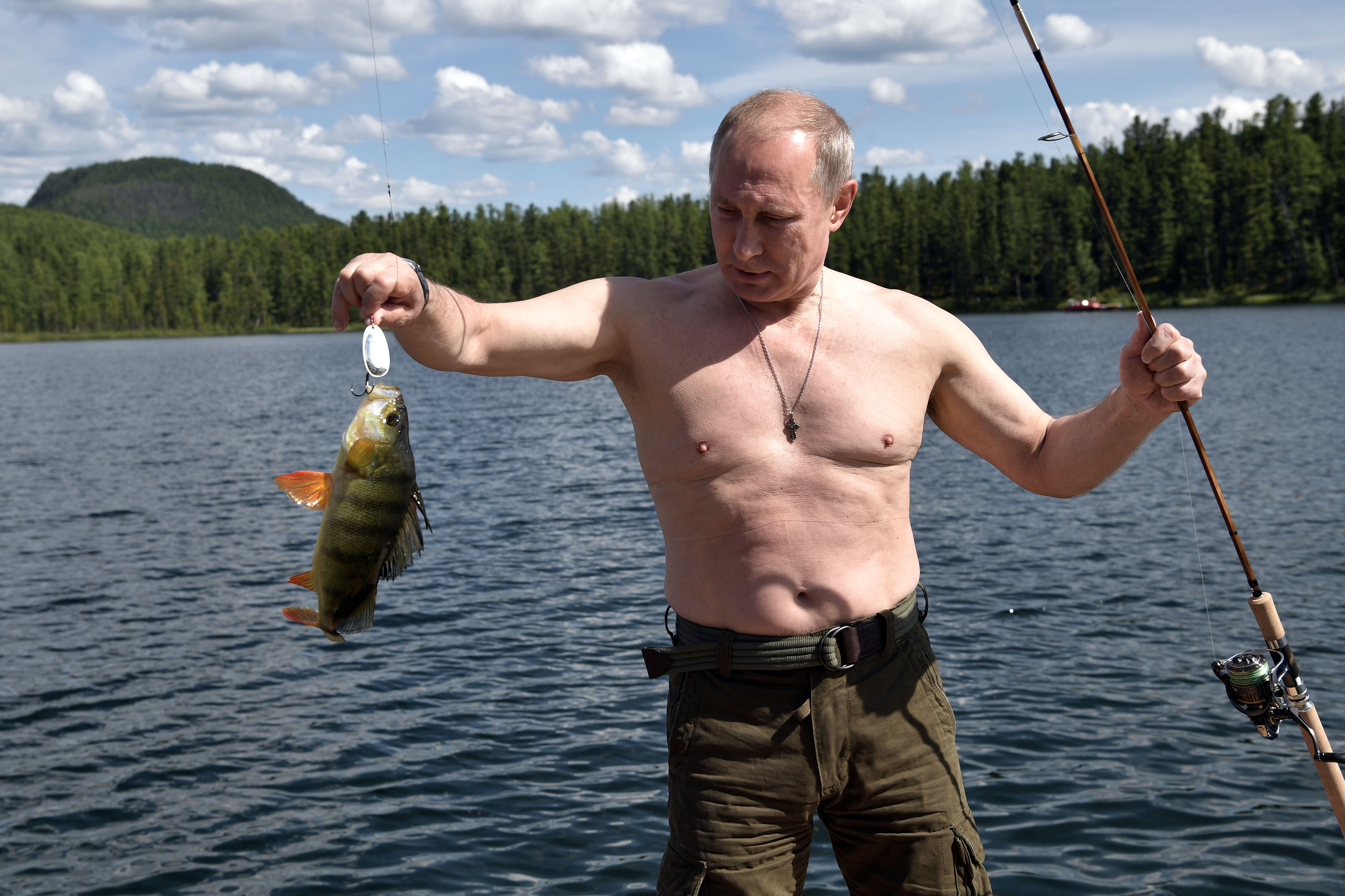 Russian President Vladimir Putin holds a fish he caught during the hunting and fishing trip which took place on August 1-3 in the republic of Tyva in southern Siberia