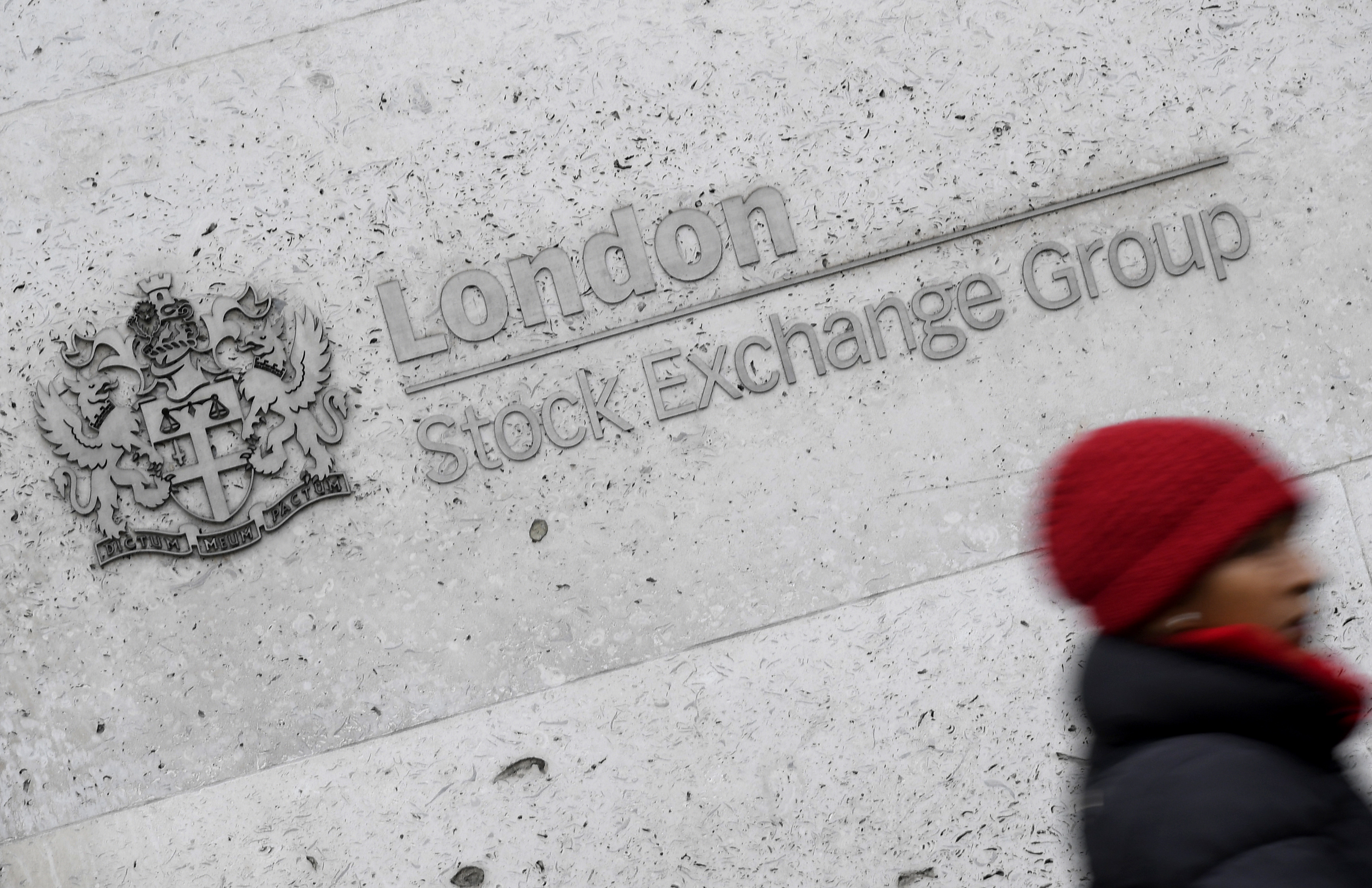 A woman walks past the London Stock Exchange building in the City of London, Britain