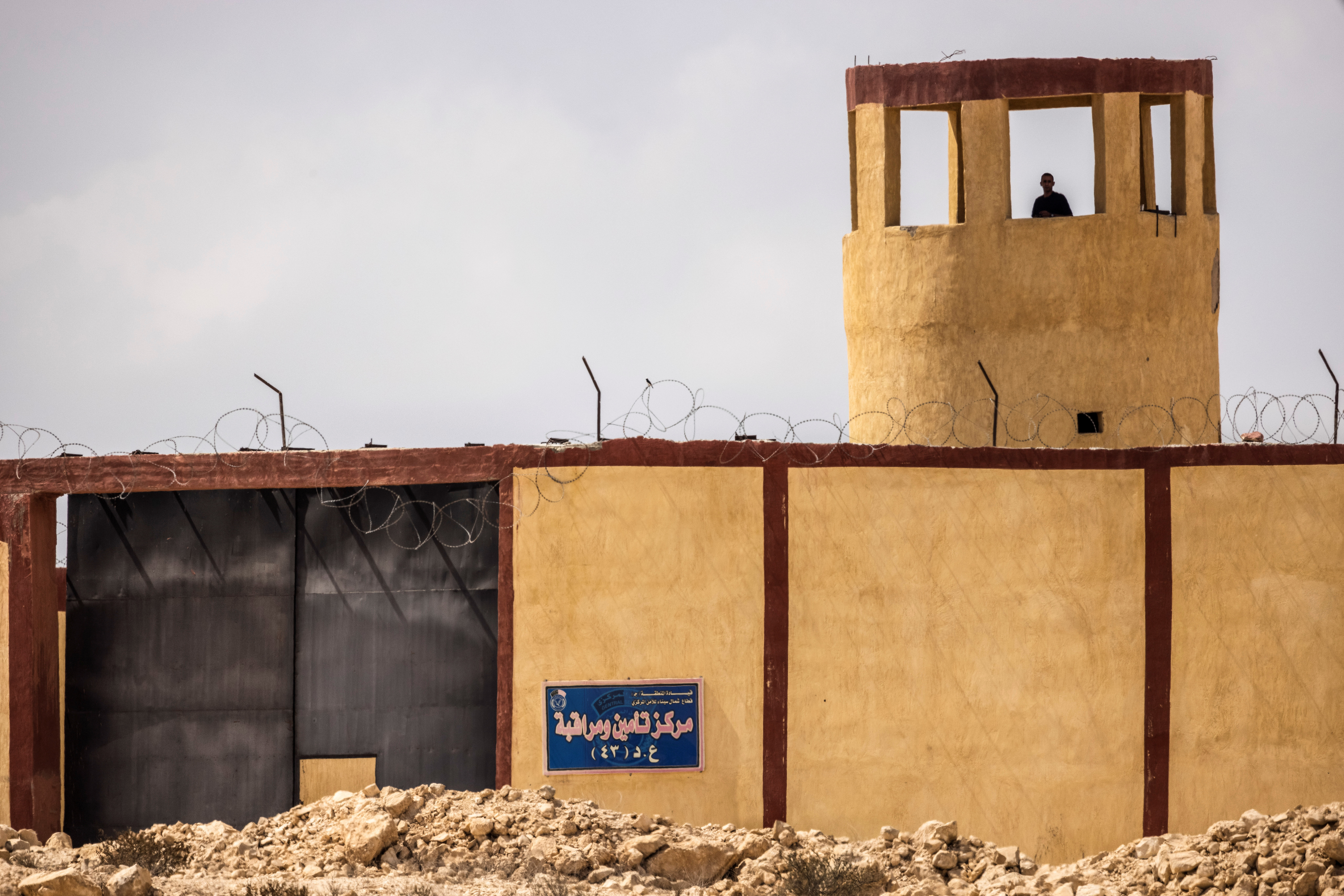 An Egyptian man stands guard in a military outpost overlooking the Israeli-Egyptian border as seen from southern Israel