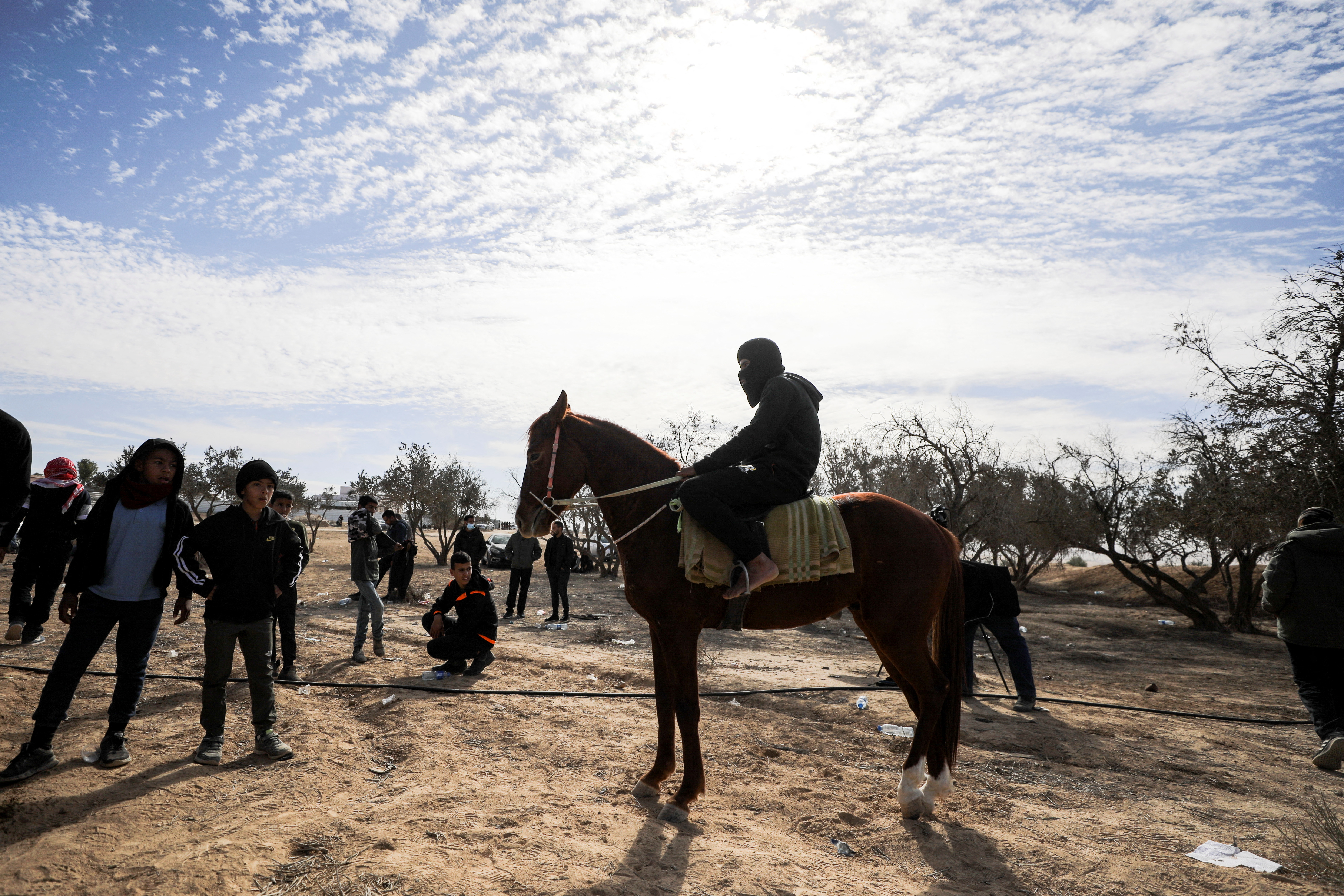 A Bedouin man sits on a horse as Bedouin children look on during a protest against forestation at the Negev desert village of Sawe al-Atrash, southern Israel