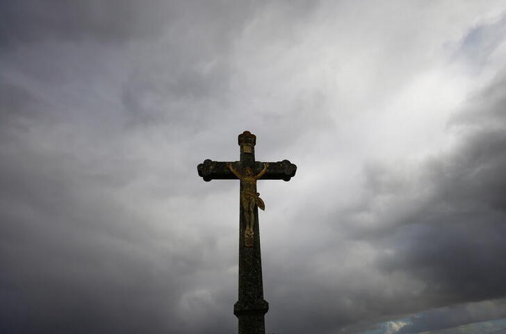 A Christian Catholic cross is silhouetted in Saint-Fiacre-sur-Maine