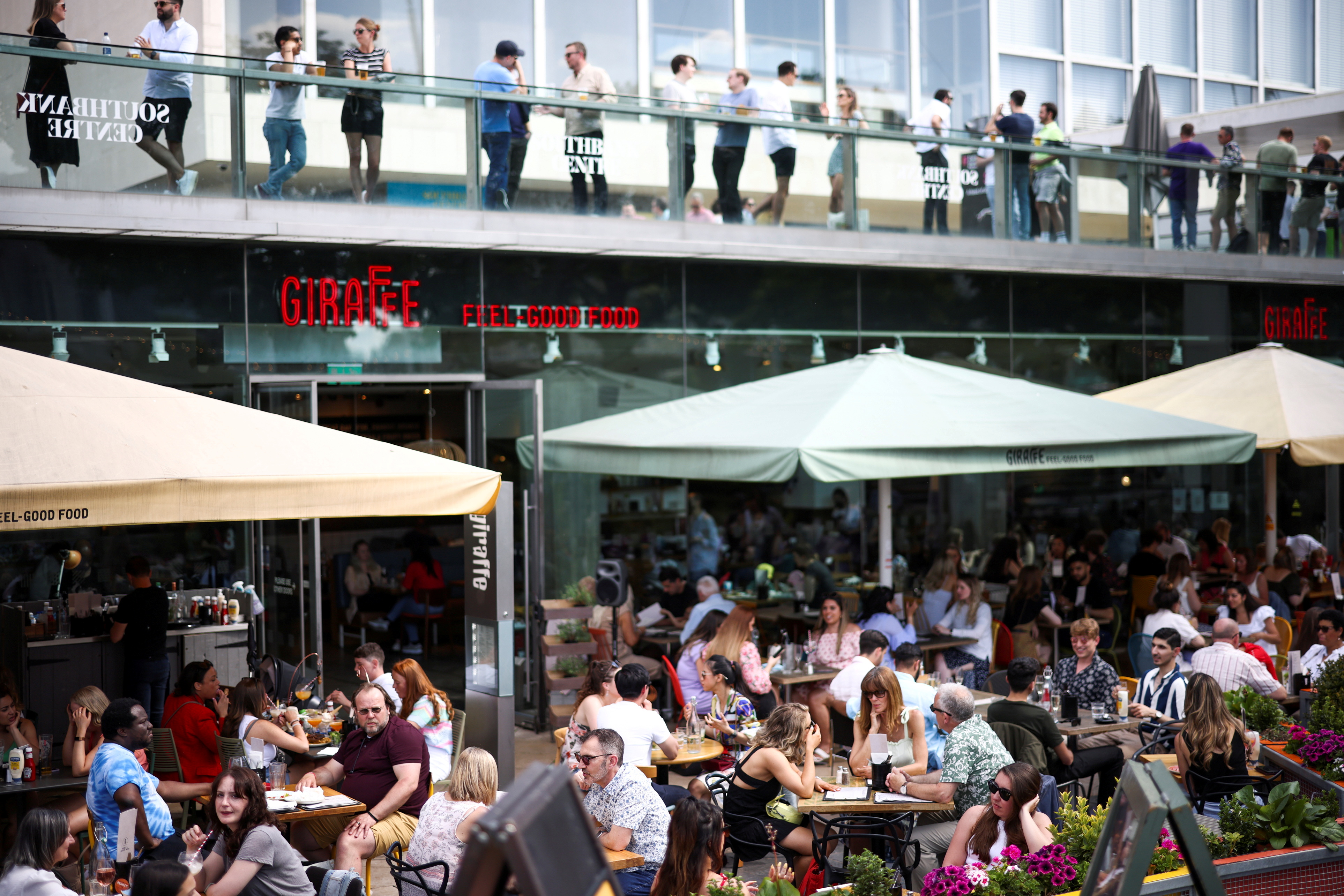 People sit at an outdoor restaurant on the South Bank during sunny weather, amid the coronavirus disease (COVID-19) outbreak, in London