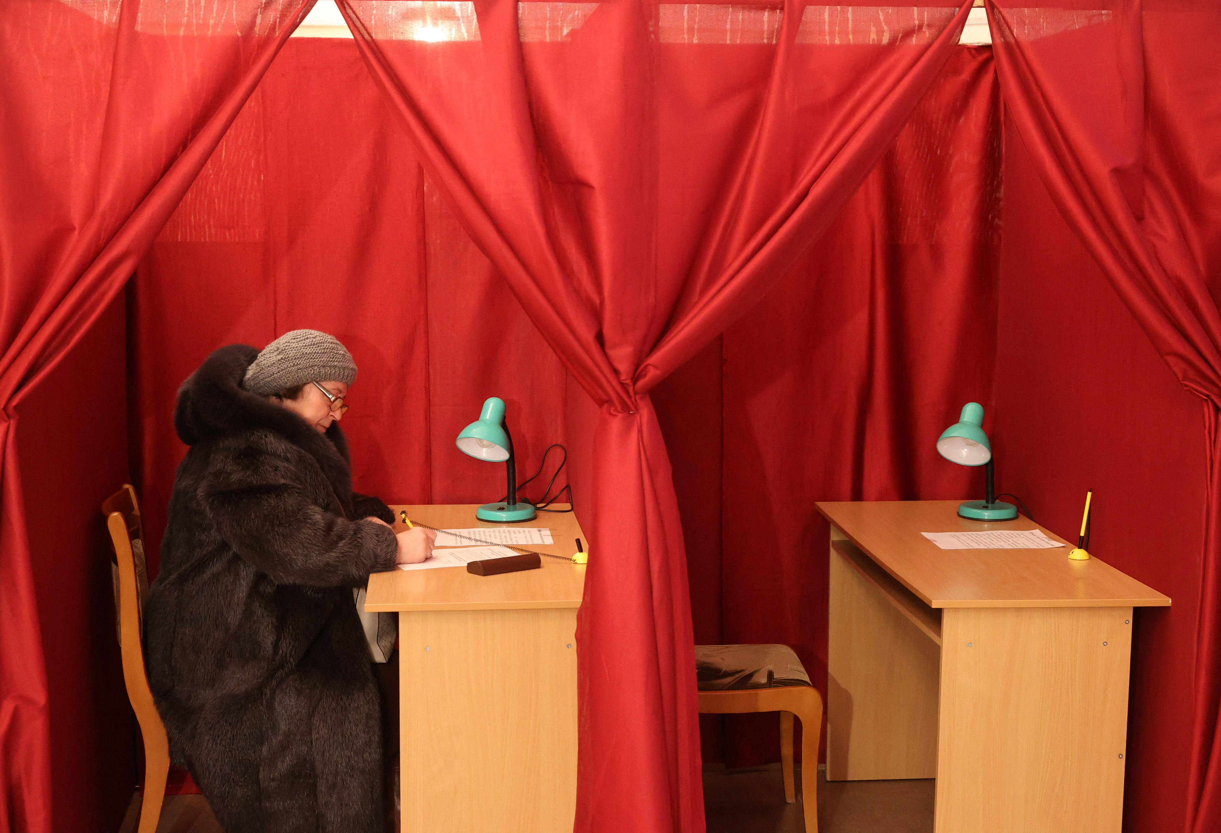 A woman fills out a ballot at the constitutional referendum in Vitebsk
