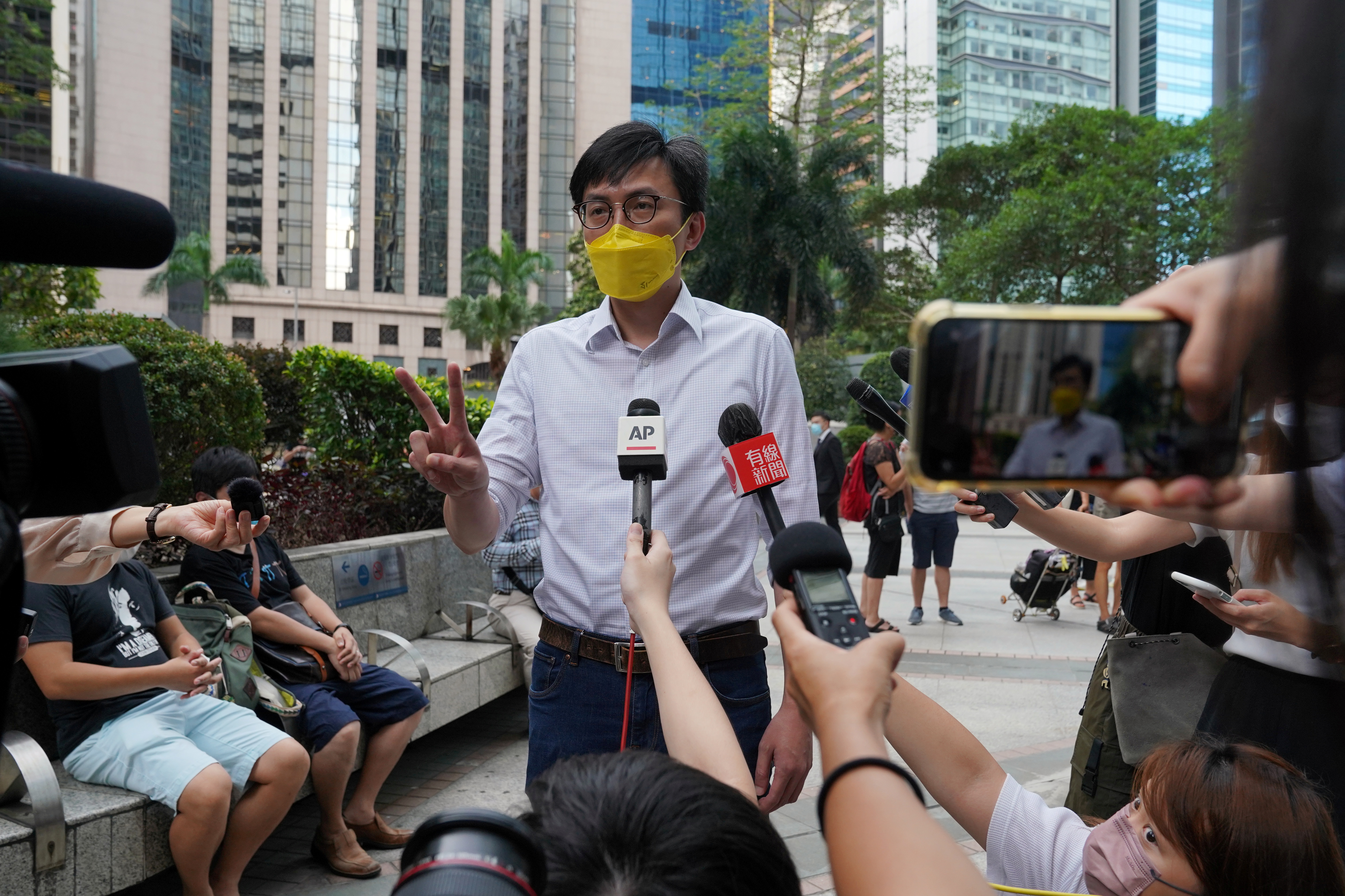 Pro-democracy activist Avery Ng gestures to the media before a trial outside the court in Hong Kong