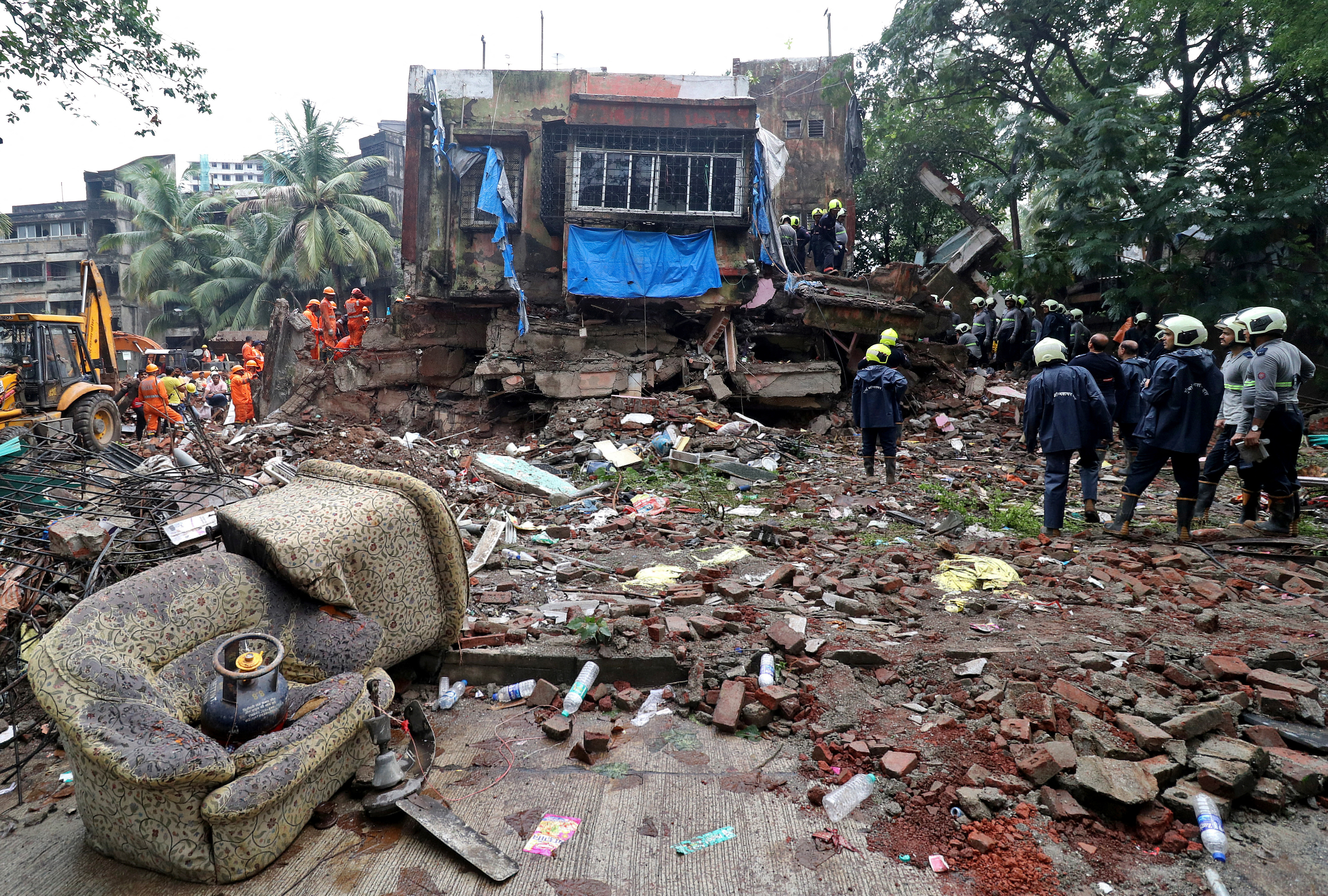 Rescue workers and firefighters search for survivors at the site of a collapsed residential building in Mumbai