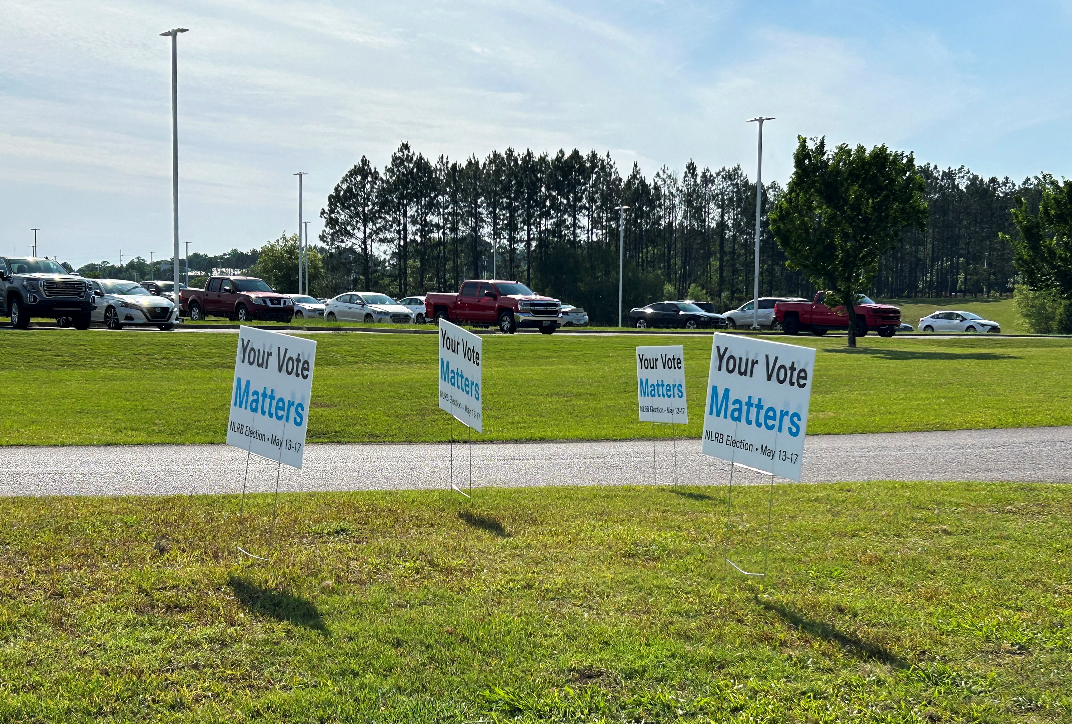 Signs urge workers to vote line the road leading up to the Mercedes plant in Vance