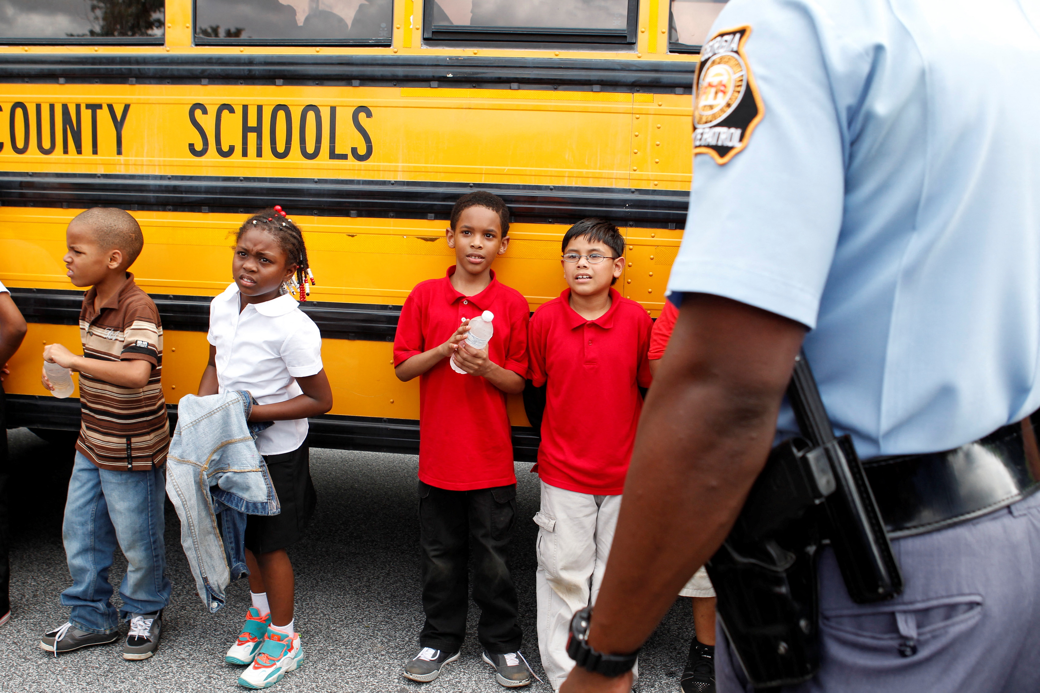 Children stand outside of their school bus in Decatur, Georgia, August 20, 2013.
